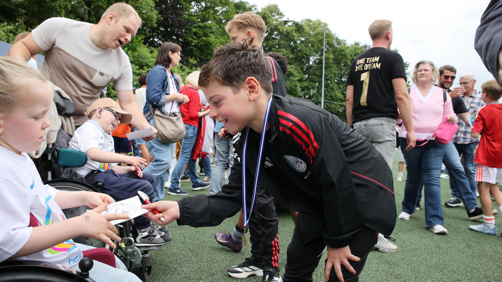 Wurden abseits des Rasens schon erste Autogramme geschrieben? Wer weiß, wie viel die nachher einmal wert sind. Hier sind es Aufkleber, die ein junger Kicker von Amsterdam verteilt.