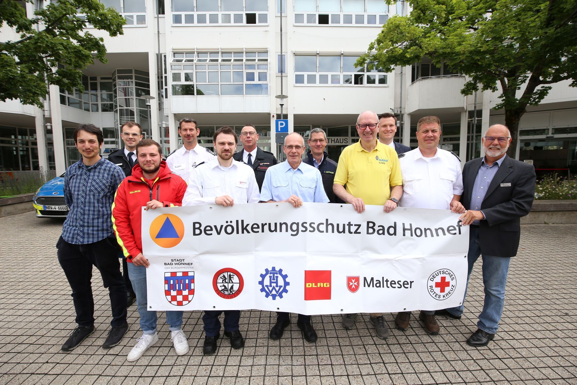 Eine Gruppe von Männern mit einem Transparent mit der Aufschrift „Bevölkerungsschutz Bad Honnef“.