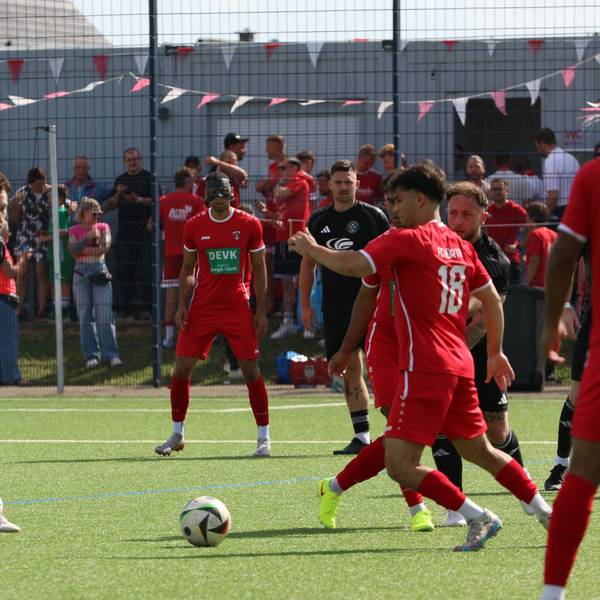 Ein Spieler von Hürth hat den Ball, sieht sich aber mehreren Spielern des TuS Zülpich entgegen.