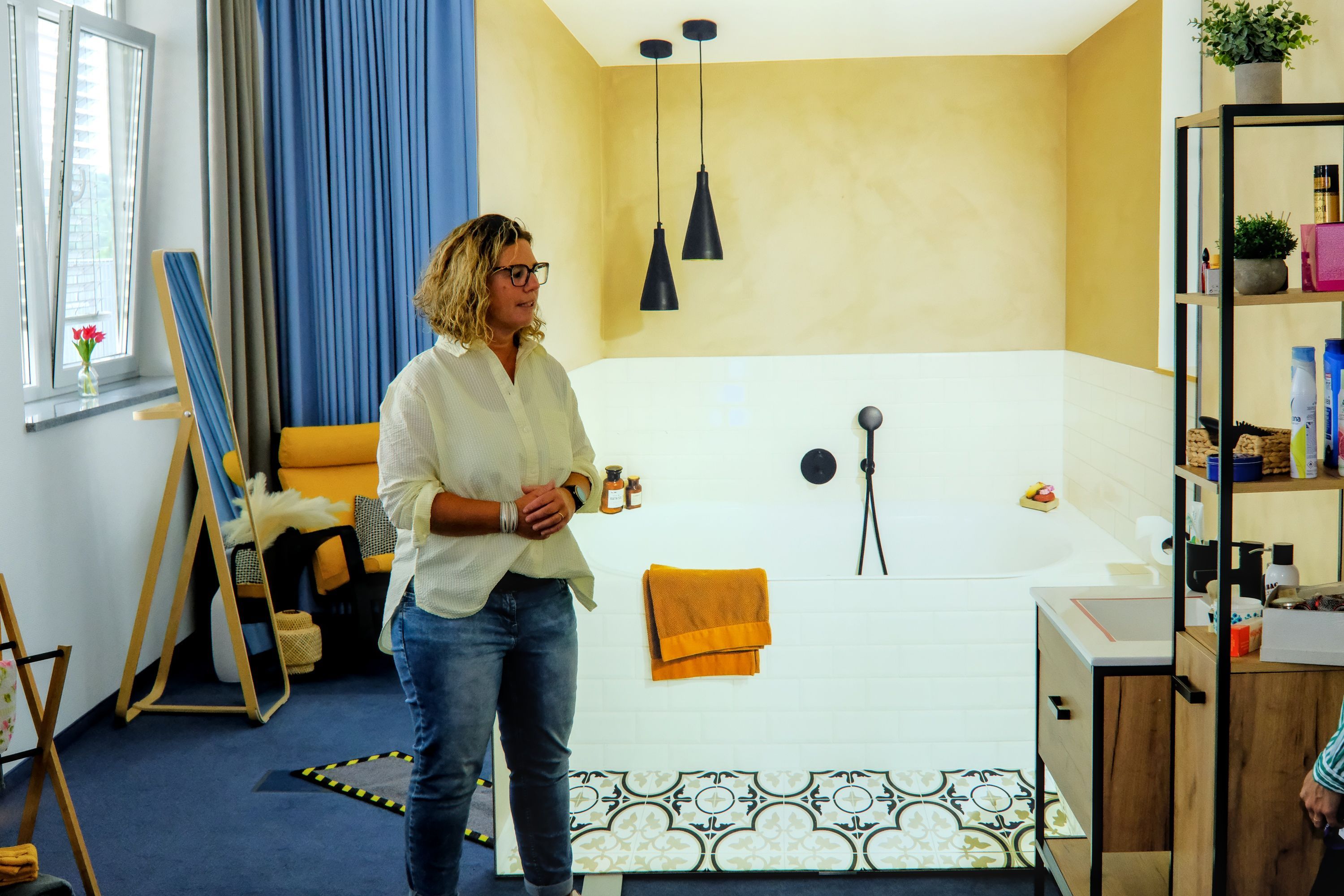 Stefanie Froitzheim, Leiterin AOK Servicestelle Demenz, steht in einer Musterwohnung für Demenzerkrankte mit offenem Badbereich.