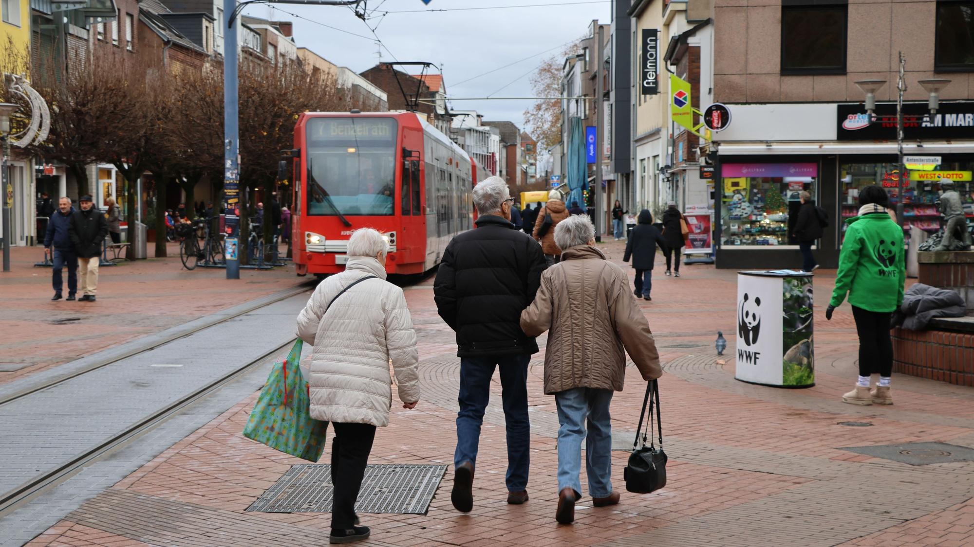 Auf dem Bild ist eine Straßenbahn zu sehen, die durch die Fußgängerzone fährt.