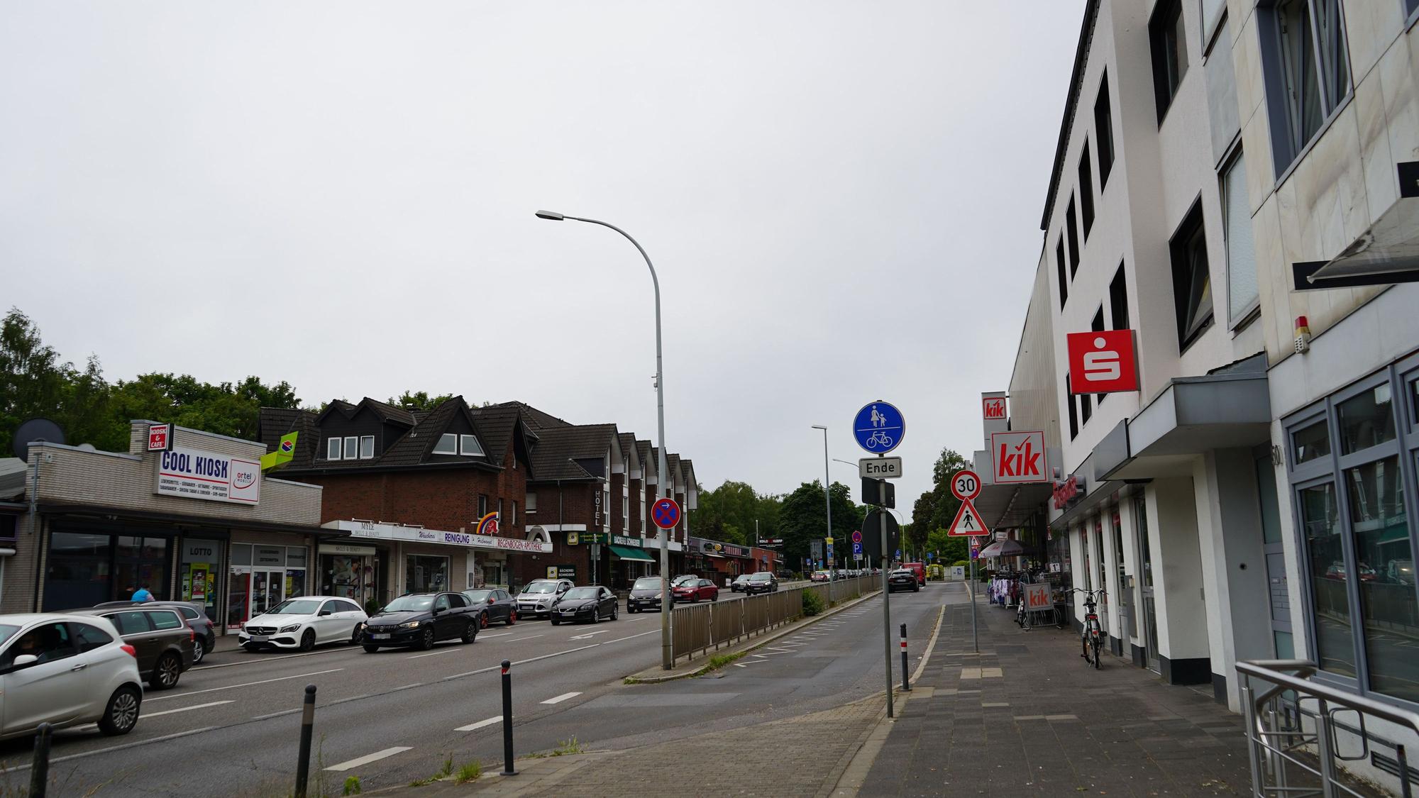 Das Bild zeigt die Dormagener Straße. Es sind viele Autos unterwegs, verschiedene Geschäfte haben sich dort angesiedelt.