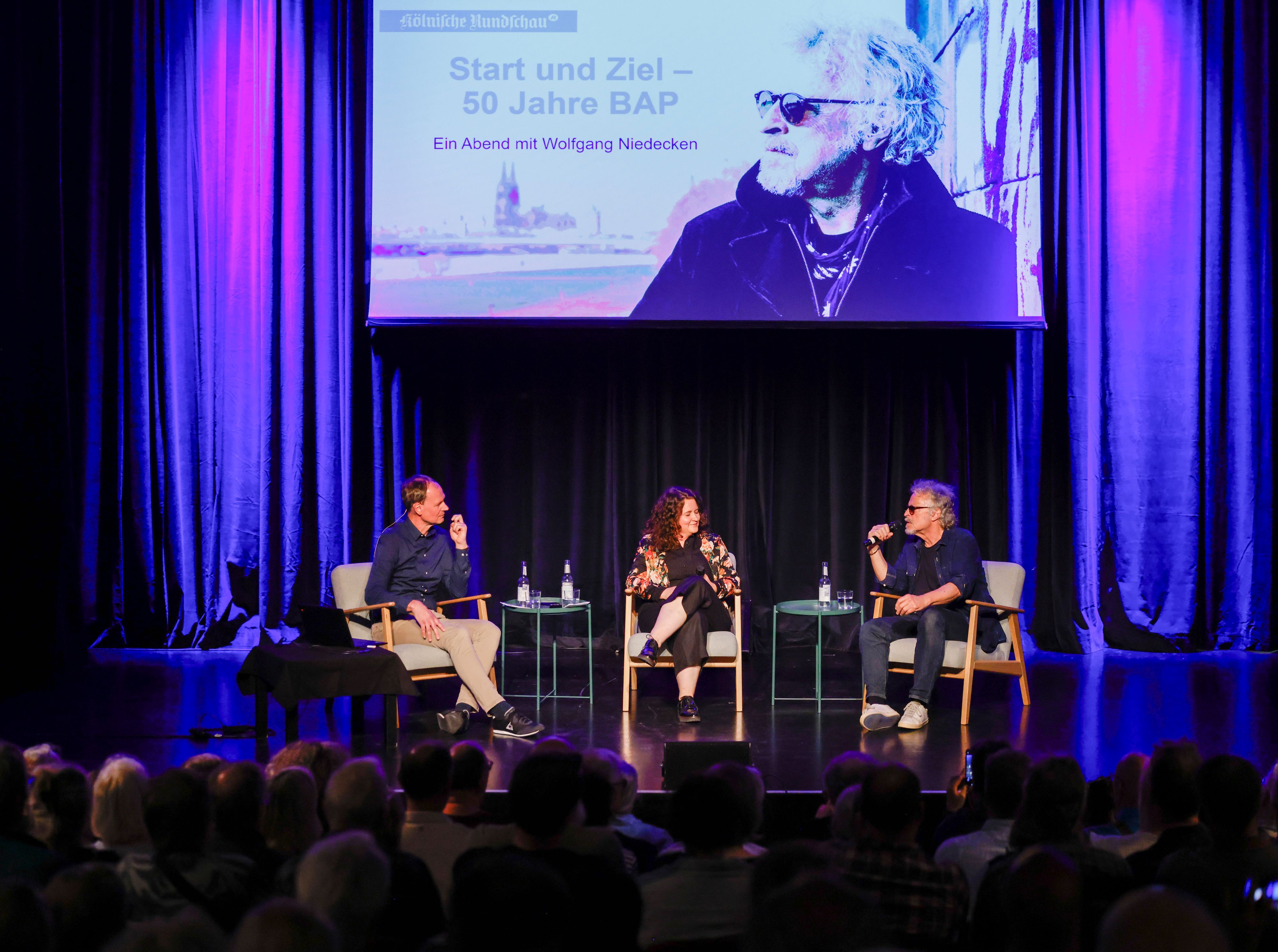 Wolfgang Niedecken (rechts) spricht in der Comedia mit Jens Meifert und Anne Burgmer.