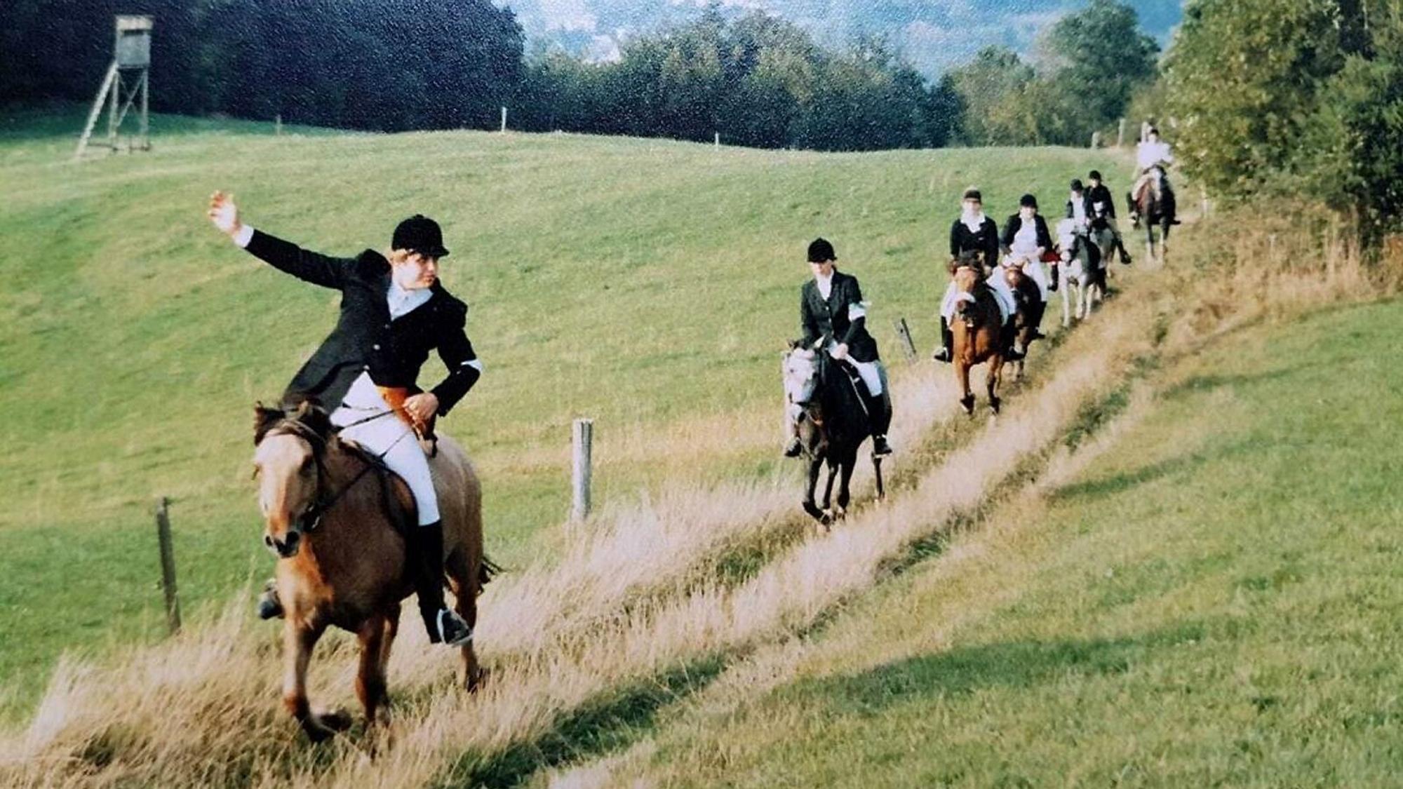 Reiter ziehen in langen Reihen über die Wiesen des Naafbachtals.