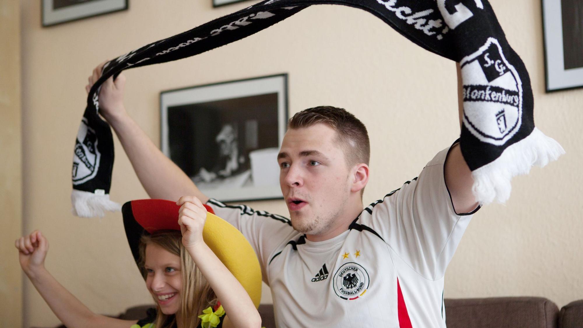 Ein Mann und seine Tochter jubeln zur Fußball-WM vor dem TV