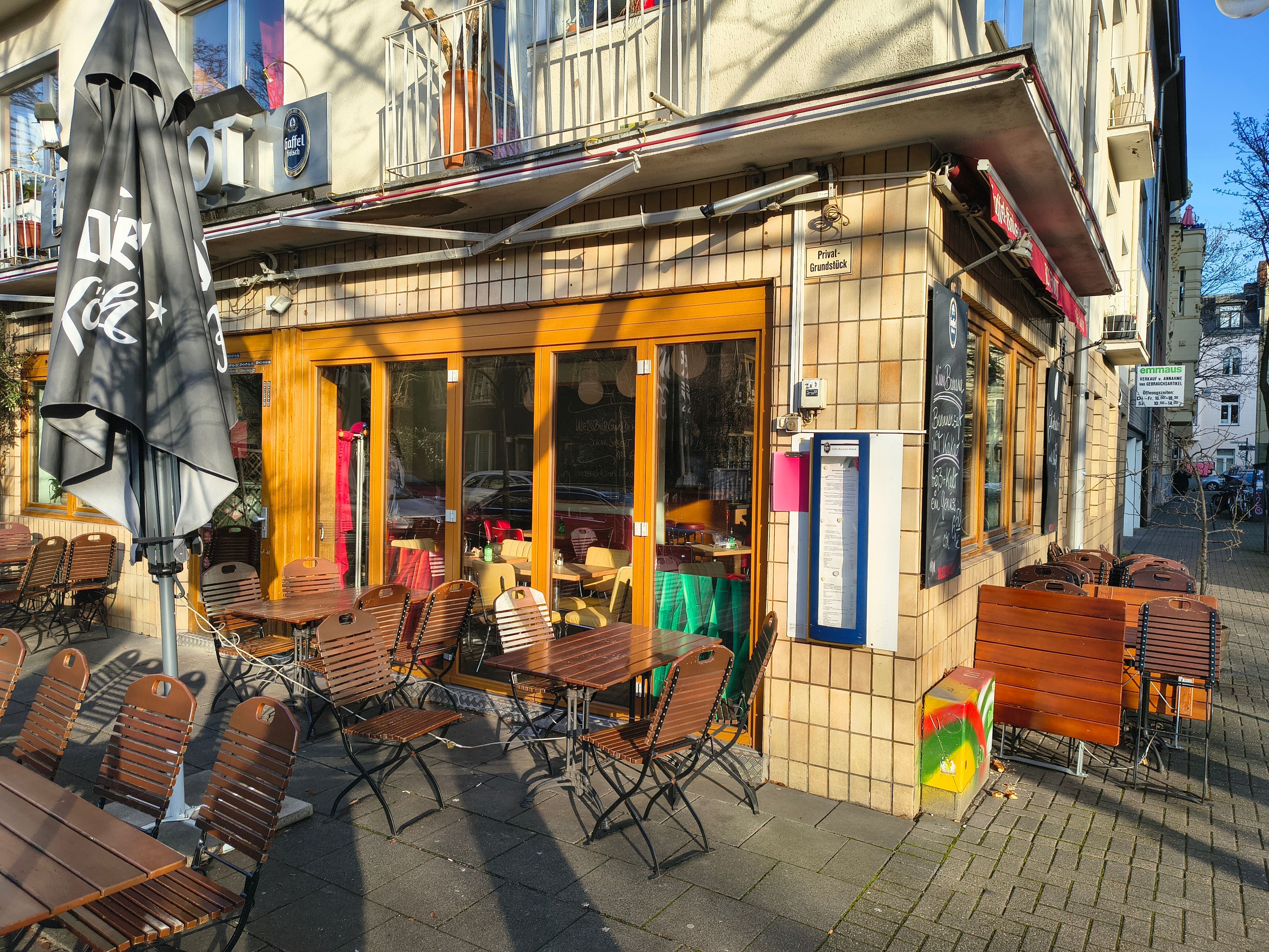 Ein geschlossenes Ecklokal mit Stühlen und Tischen auf der Terrasse