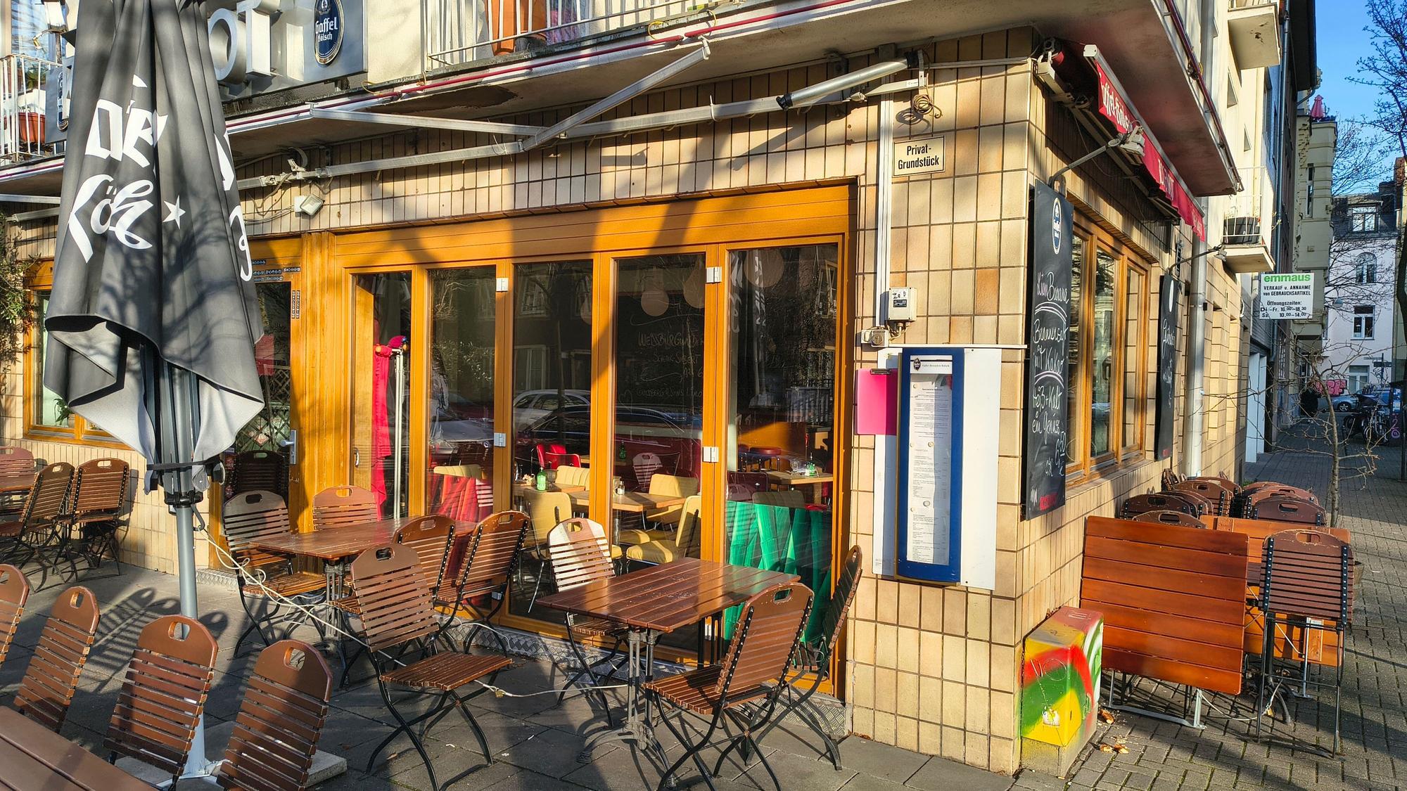 Ein geschlossenes Ecklokal mit Stühlen und Tischen auf der Terrasse