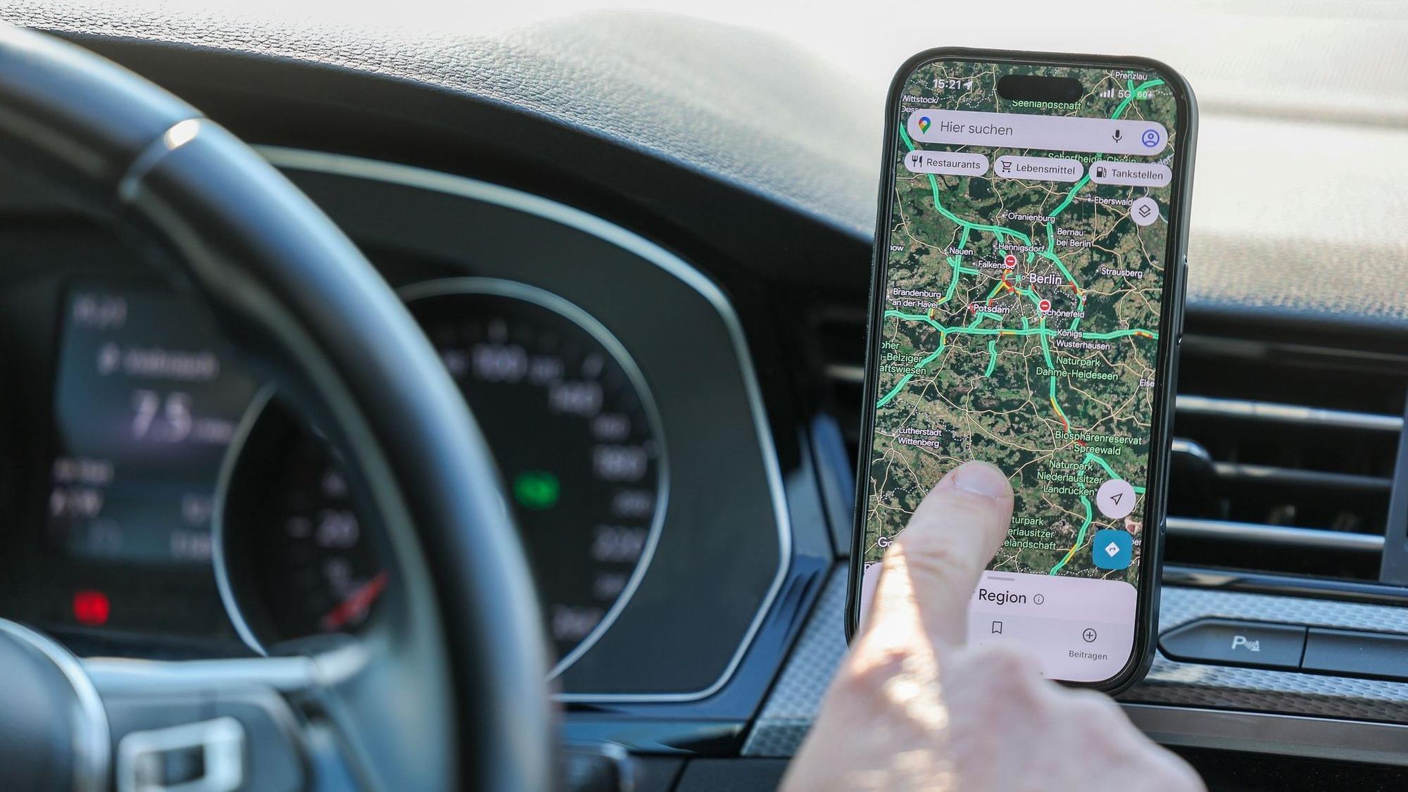 Ein Mann nutzt ein Smartphone im Auto