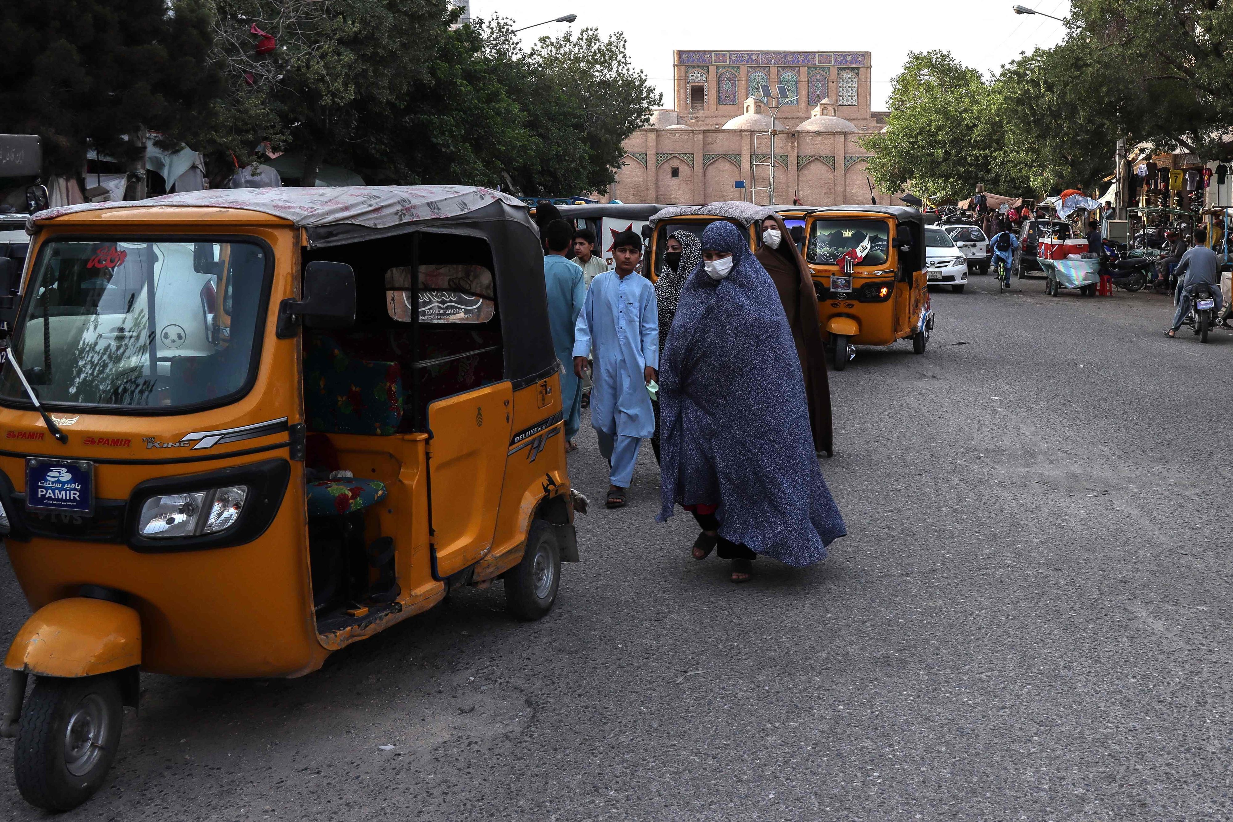 Afghanische Frauen in Tschadoren gehen am 8. Juni 2026 nahe der Großen Moschee in Herat eine Straße entlang.