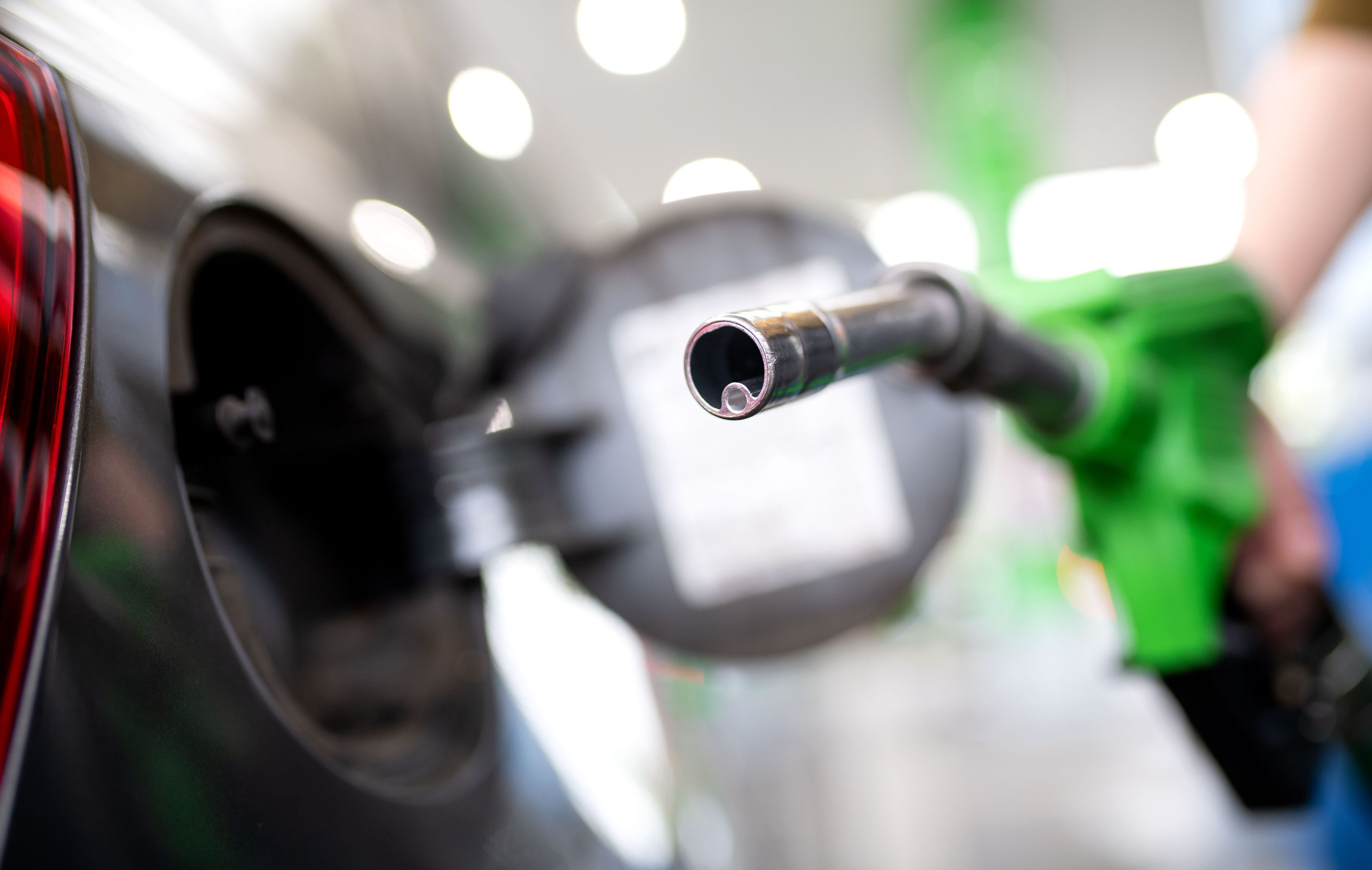 Eine Frau hält an einer Tankstelle an einer Zapfsäule eine Zapfpistole in der Hand und betankt ein Auto. In Russland gibt es mit Kraftstoffen Probleme. (Symbolbild)