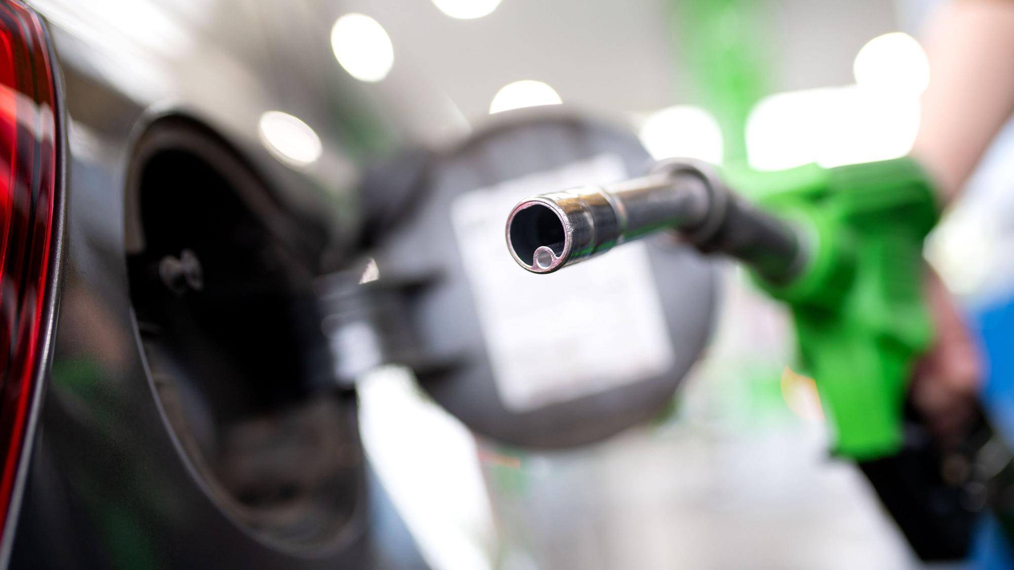 Eine Frau hält an einer Tankstelle an einer Zapfsäule eine Zapfpistole in der Hand und betankt ein Auto. In Russland gibt es mit Kraftstoffen Probleme. (Symbolbild)