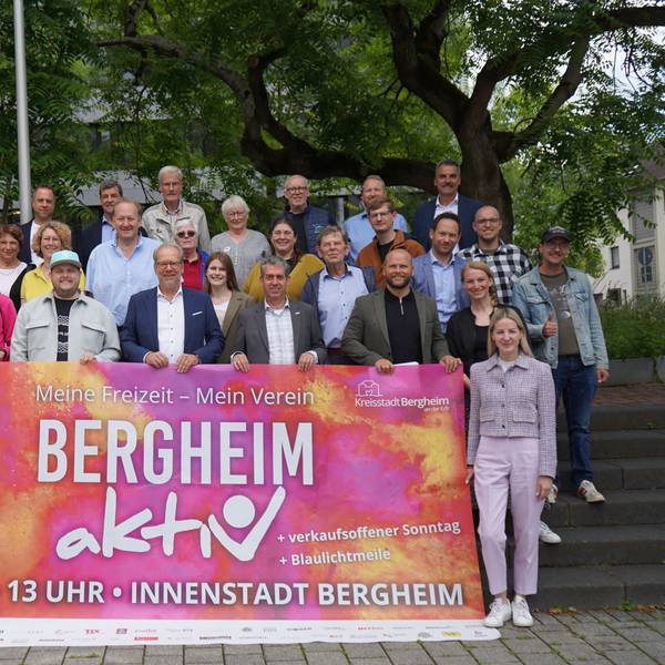 Das Bild zeigt ein Banner mit der Aufschrift „Bergheim aktiv“. Vertreter der Verwaltung sowie der vielen Vereine und Sponsoren haben sich zu einem Gruppenbild versammelt.