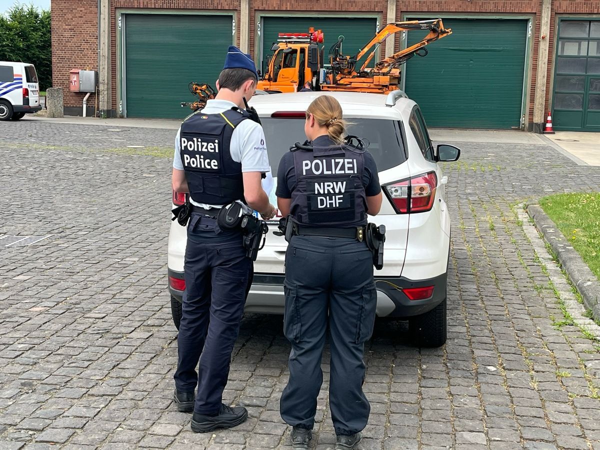 Polizisten und Polizistinnen kontrollieren ein Auto bei einer großangelegten Verkehrskontrolle.