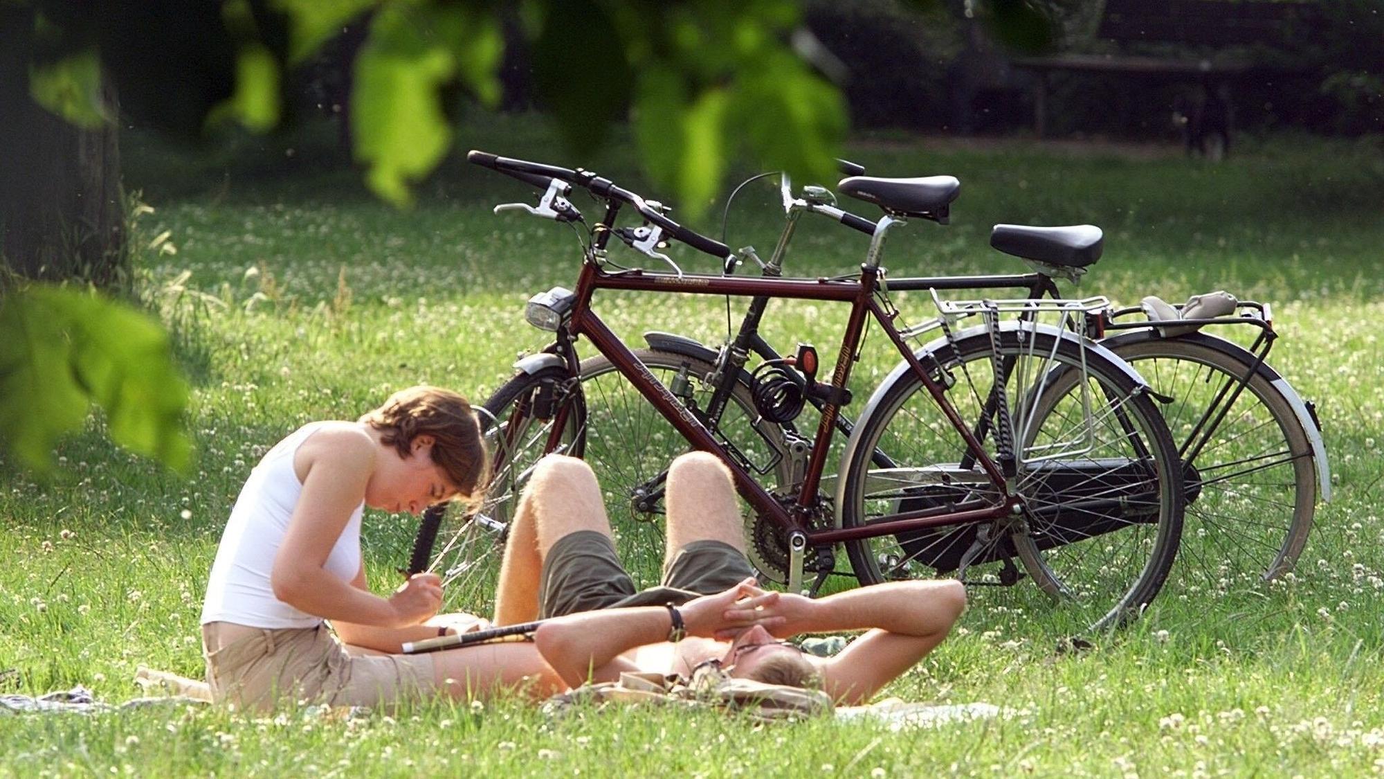 Ein junges Pärchen liegt am Samstag am Kölner Grüngürtel neben den Fahrrädern auf einer Decke in der Sonne. Köln zählt laut Auswertung als „Overperformer“ im Glücksatlas – die Bewohner der Stadt empfinden ihre Lebensqualität als hoch, trotz nicht optimaler Bedingungen. (Archivbild)