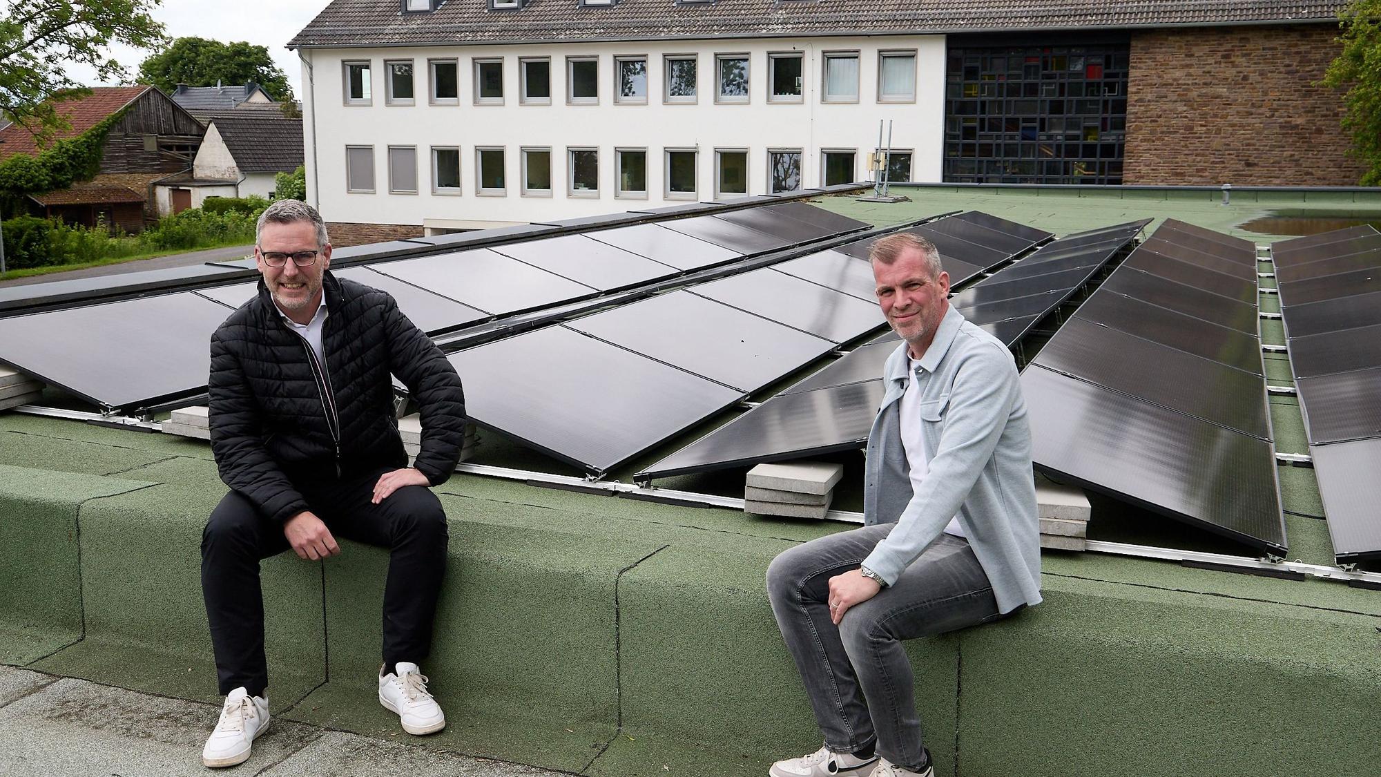 Norbert Crump und Jens Berbuir sitzen an der Photovoltaikanlage auf dem Dach des Feuerwehrgerätehauses.