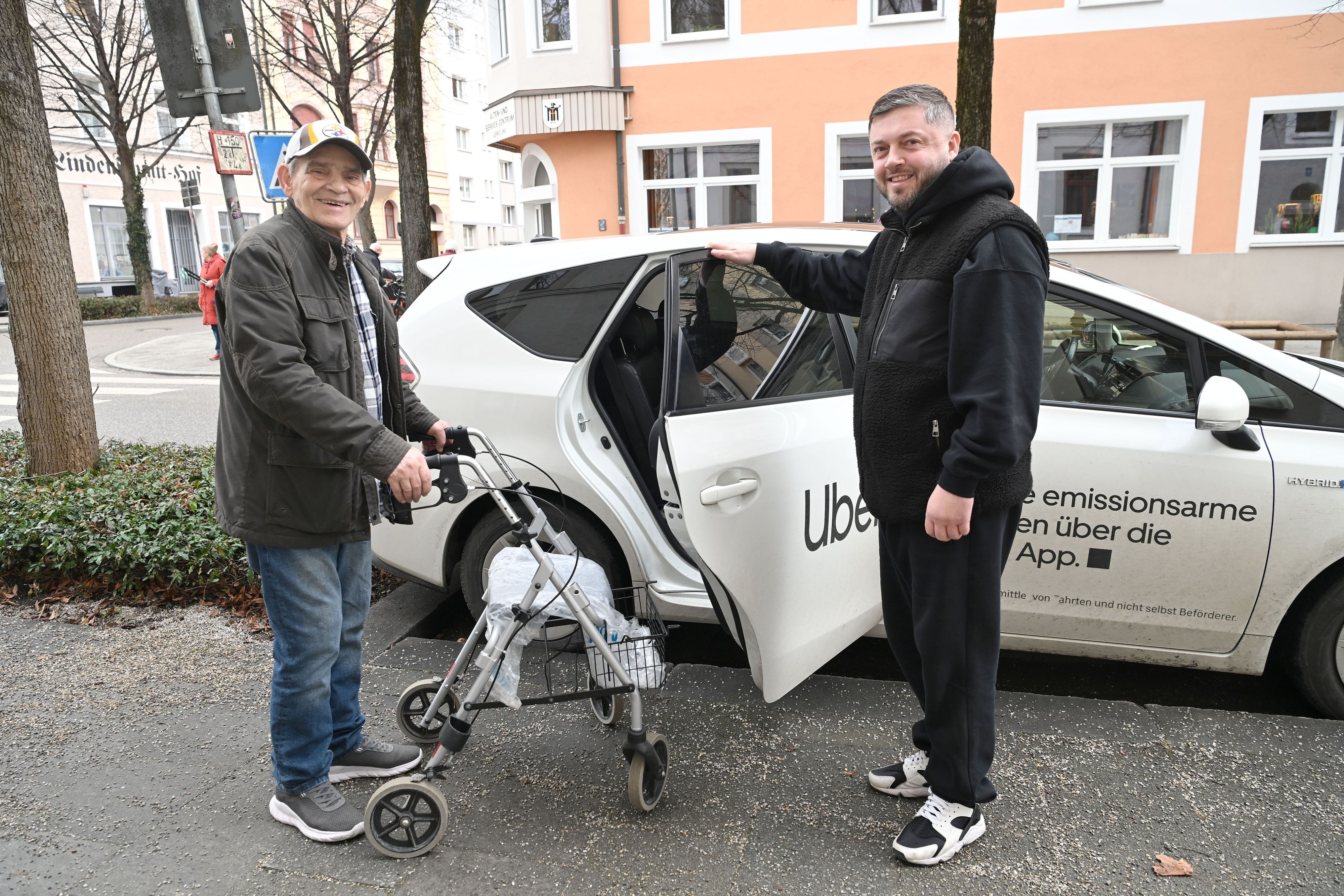 Uber-Fahrer hält Fahrgast die Tür auf.