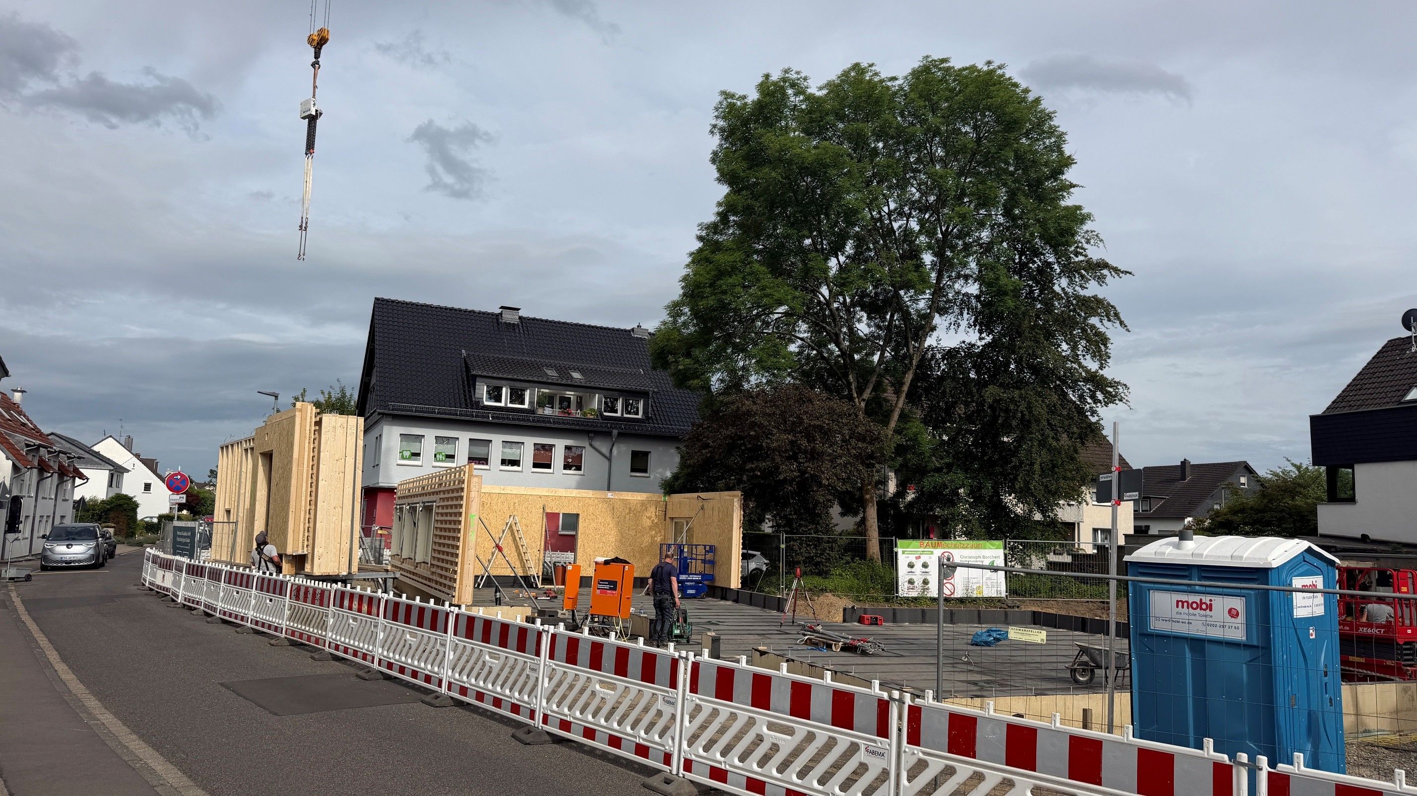 Man sieht das mit Bauzäunen abgesperrte Baugrundstück.