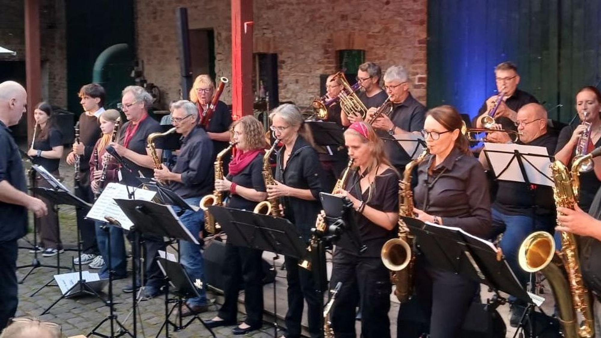 Die Band Brazzanova steht auf einem Hof und musiziert.