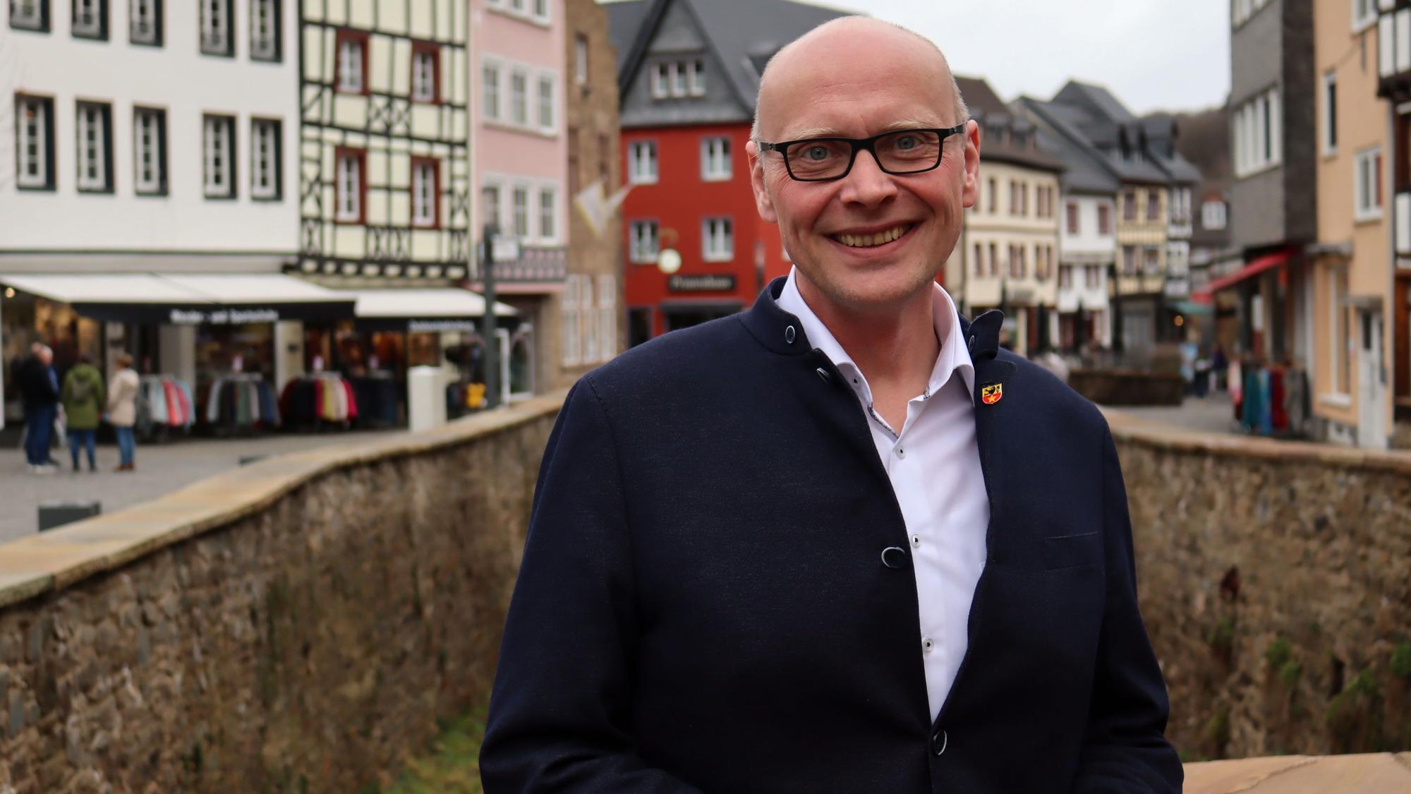 Sebastian Glatzel steht auf einer Brücke, im Hintergrund die Häuser von Bad Münstereifel.