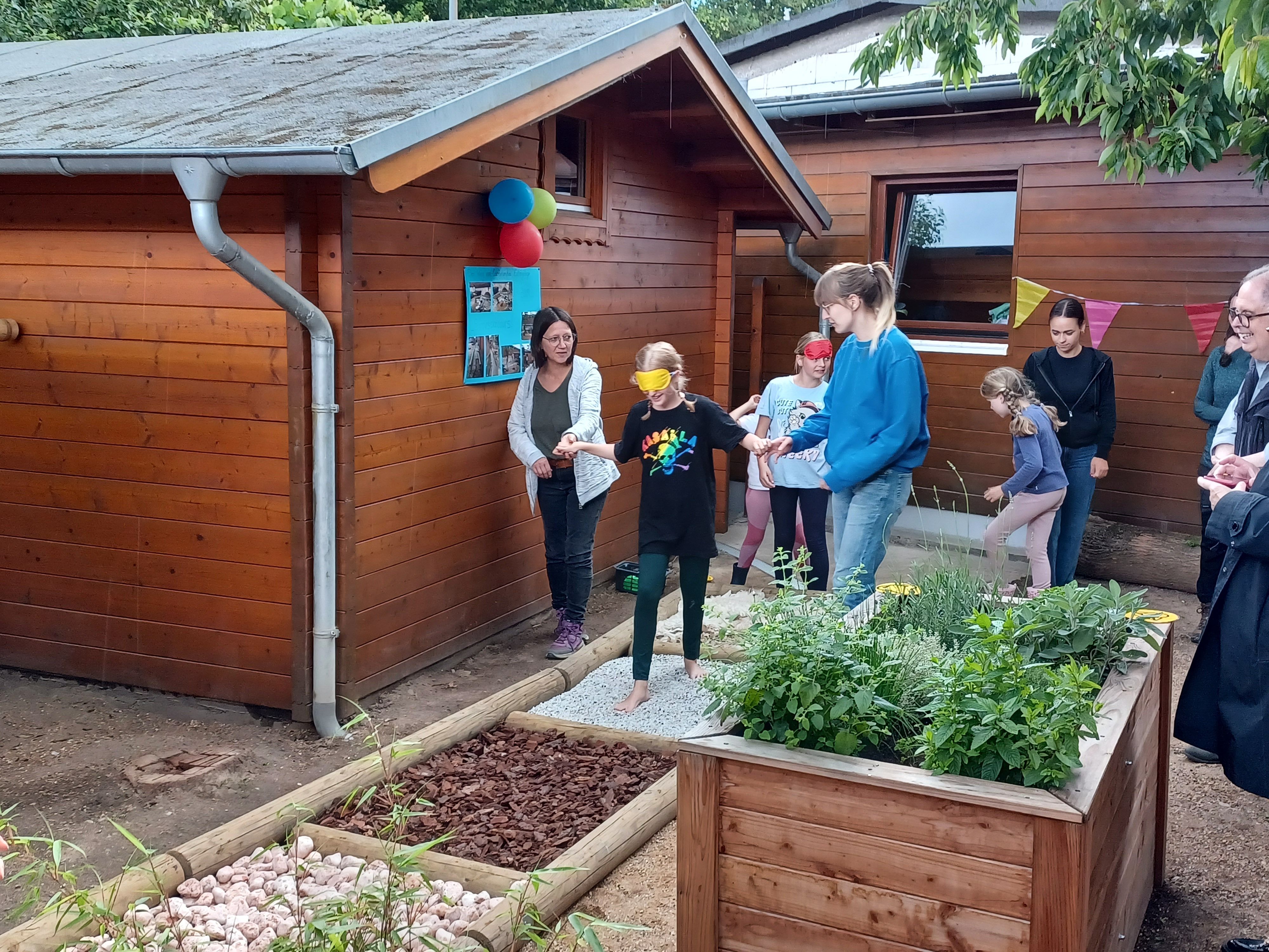 Kinder probieren einen neuen Barfuß-Erlebnispfad auf dem Wilhelmshof in Longerich aus.