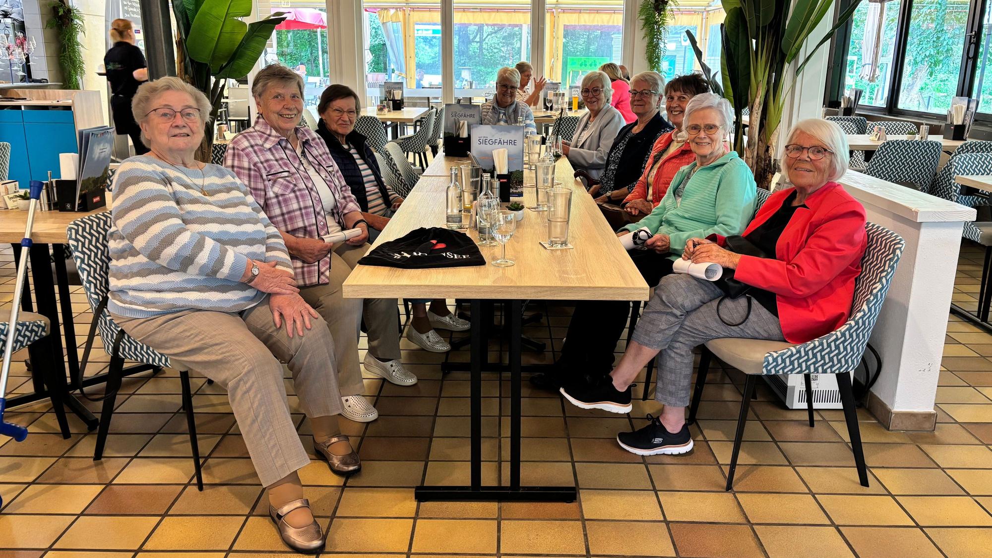 Eine Gruppe Seniorinnen sitzt an zwei zusammengeschobenen Tischen im Restaurant „Zur Siegfähre“.