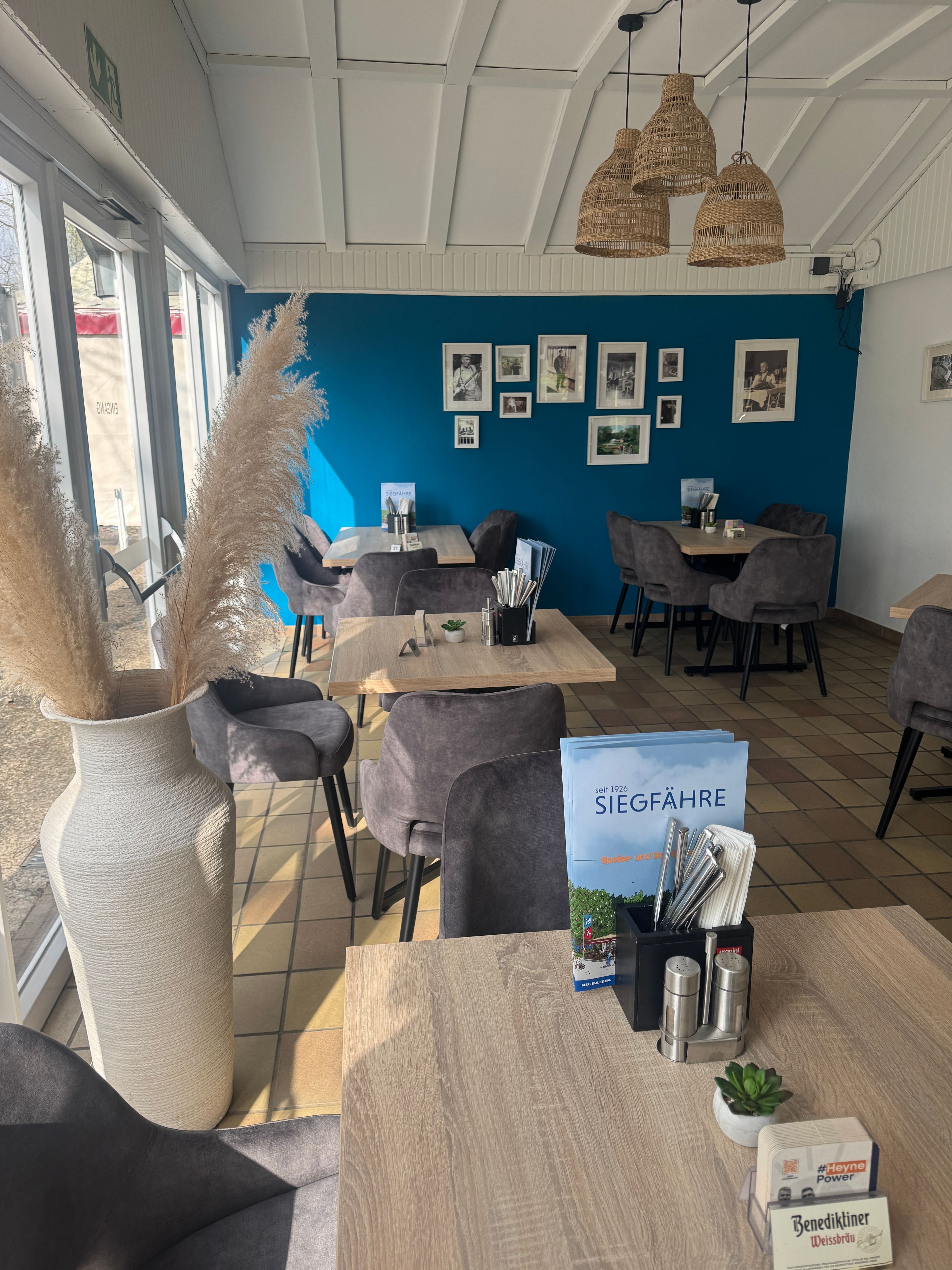 Blick auf das Mobiliar des Restaurants „Zur Siegfähre“: An kleinen Tischen stehen Stühle, dazwischen wurde recht viel Platz gelassen.