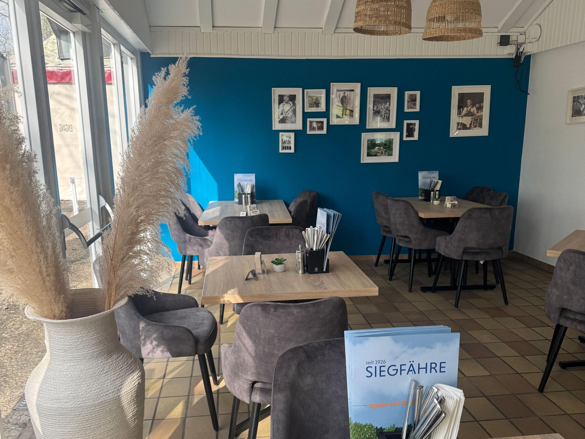 Blick auf das Mobiliar des Restaurants „Zur Siegfähre“: An kleinen Tischen stehen Stühle, dazwischen wurde recht viel Platz gelassen.