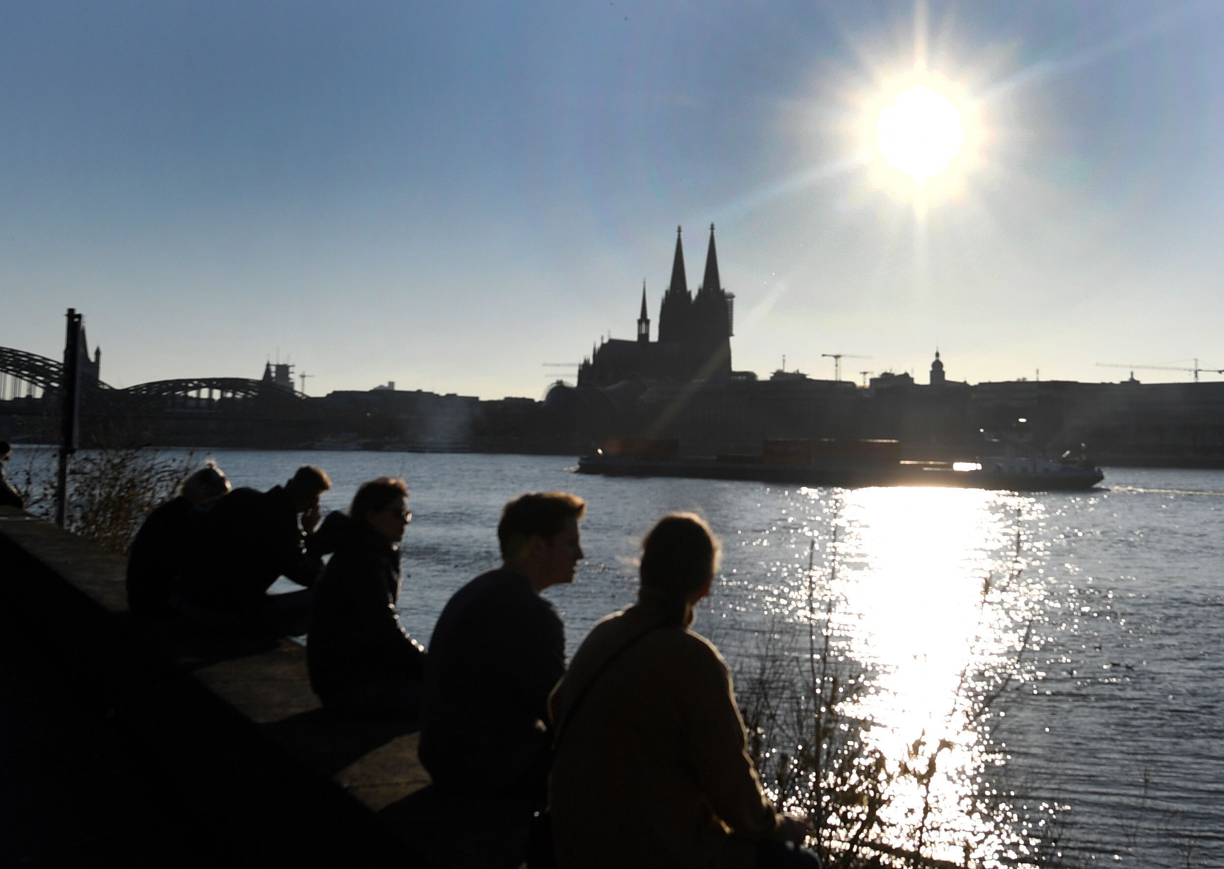 Menschen genießen die Sonne vor dem Dom. (Symbolbild)