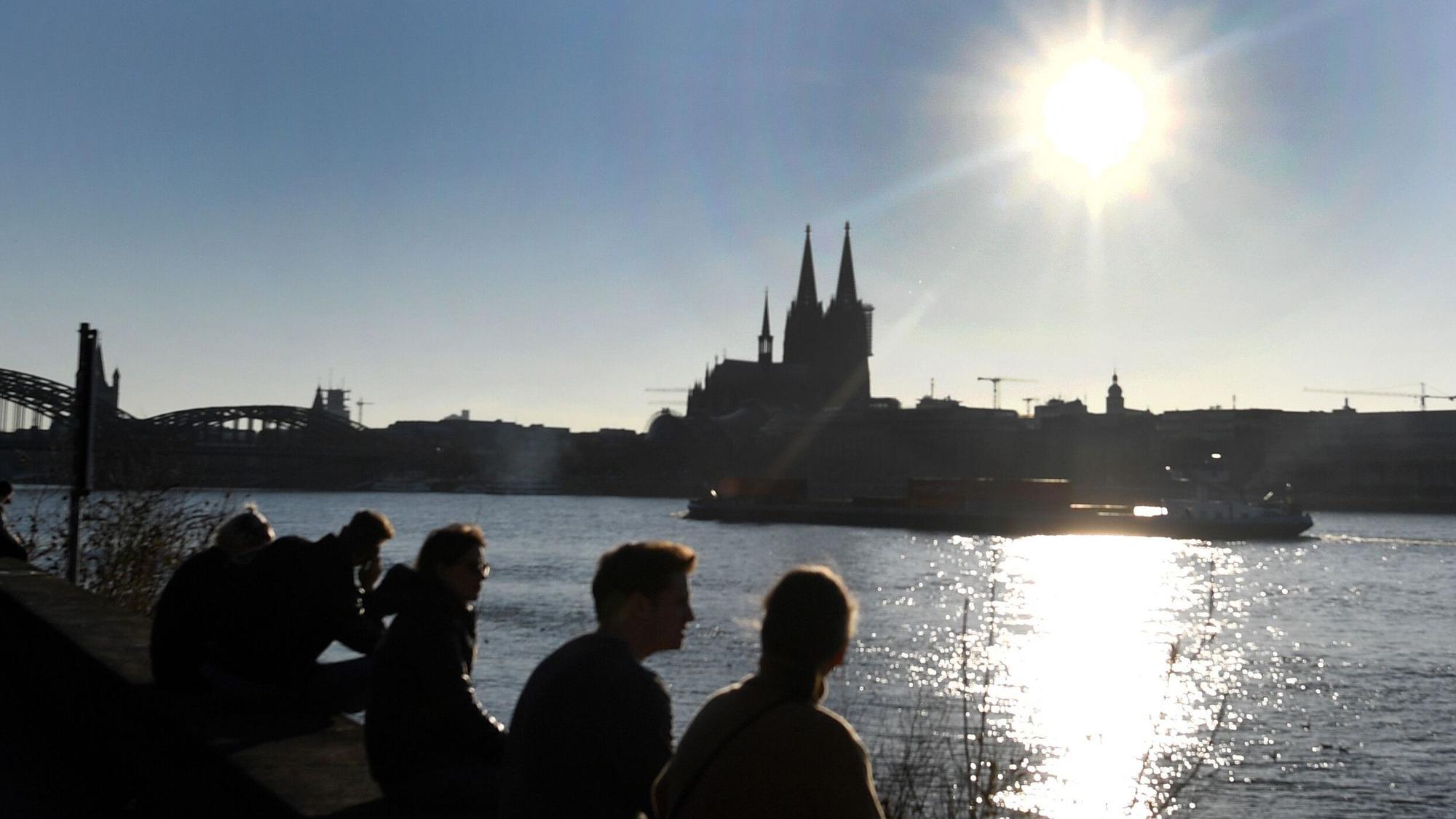 Menschen genießen die Sonne vor dem Dom. (Symbolbild)