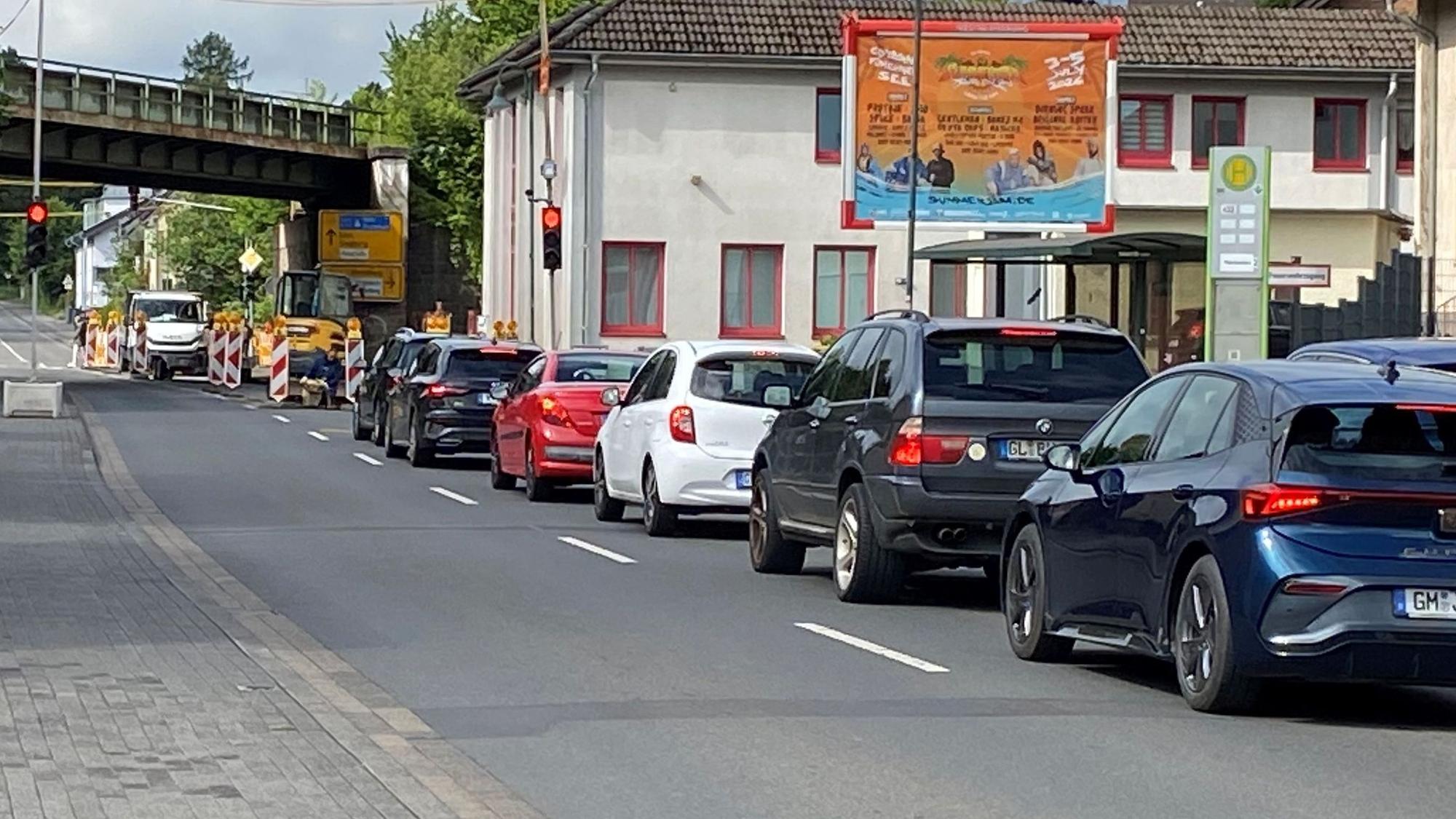 Eine Reihe Autos, die an einer roten Ampel warten.