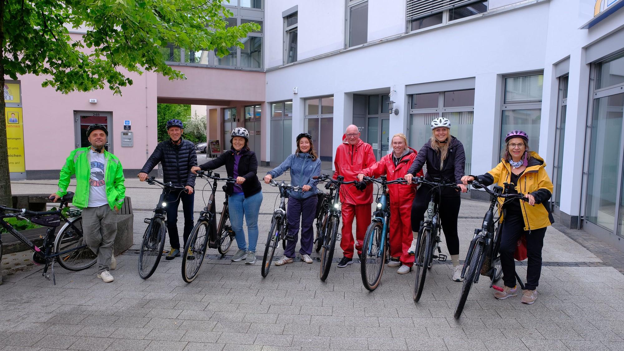 Eine Radfahrergruppe lächelt in die Kamera.
