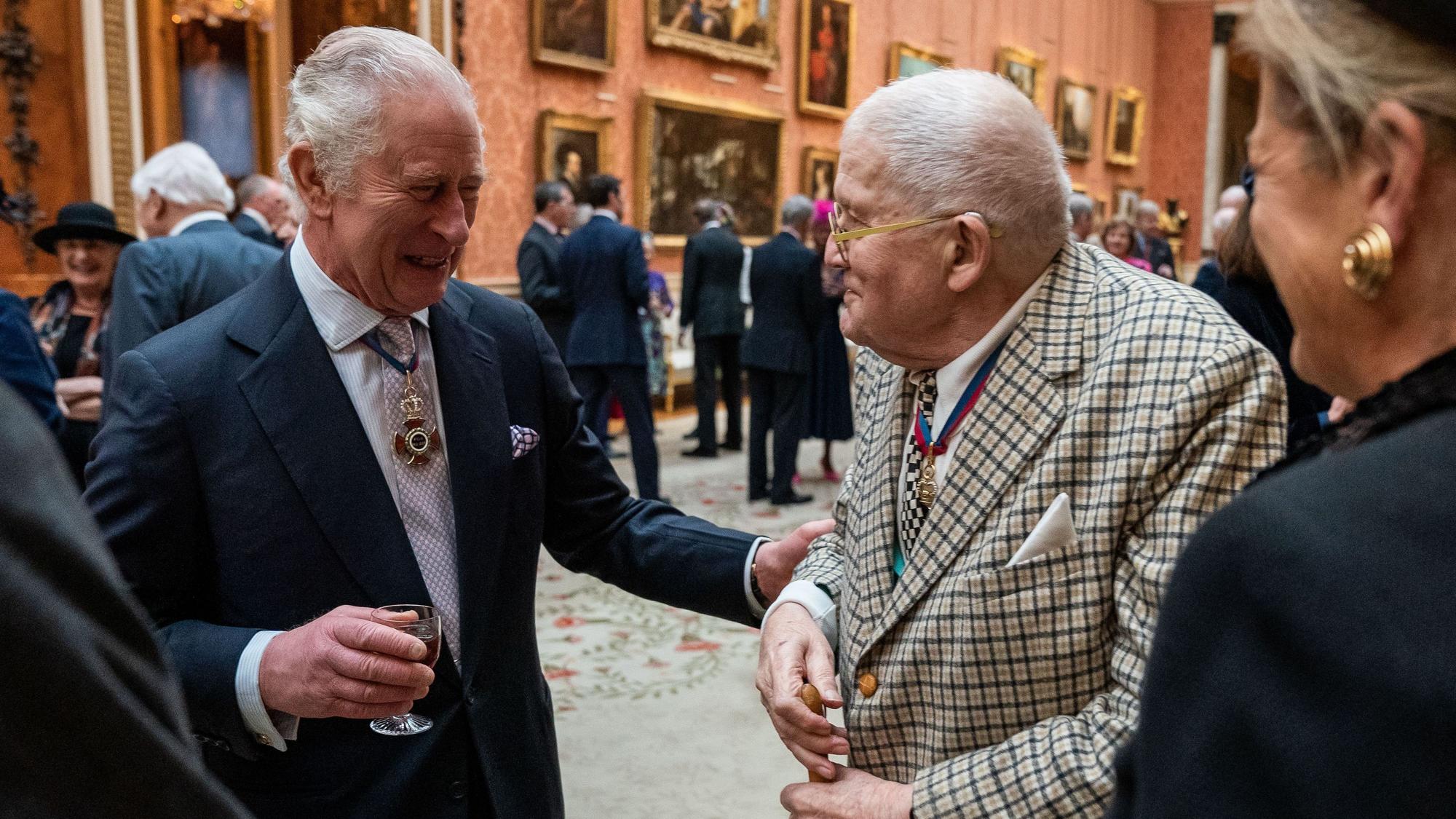 24.11.2022, Großbritannien, London: König Charles III. (l) im Gespräch mit David Hockney während eines Mittagessens für Mitglieder des Order of Merit im Buckingham Palace: Der legendäre britische Maler ist tot. Er starb im Alter von 88 Jahren «friedlich zu Hause», wie die Nachrichtenagentur PA unter Berufung auf seinen Publizisten mitteilte.
