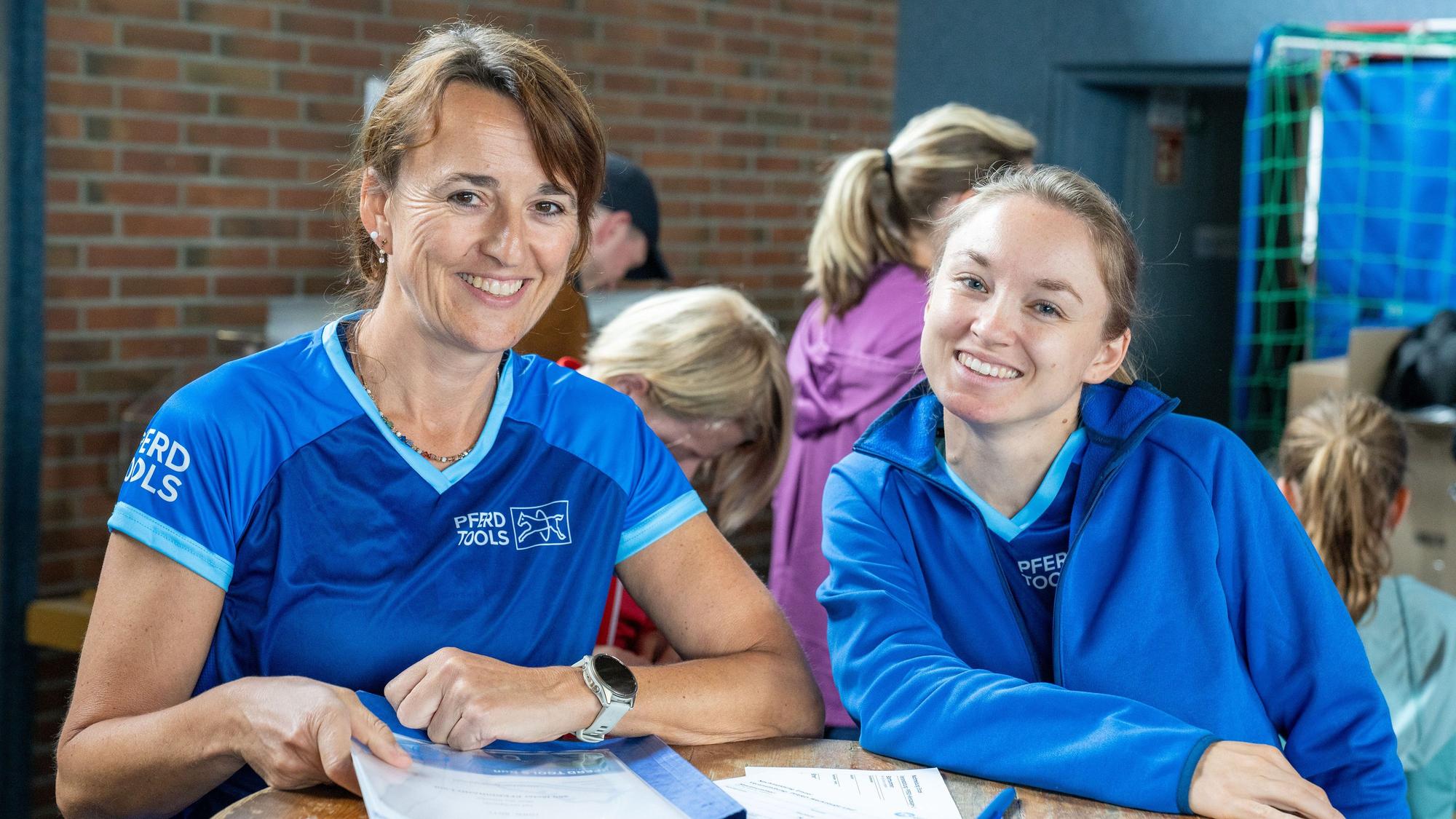Zwei Frauen lachen in die Kamera.