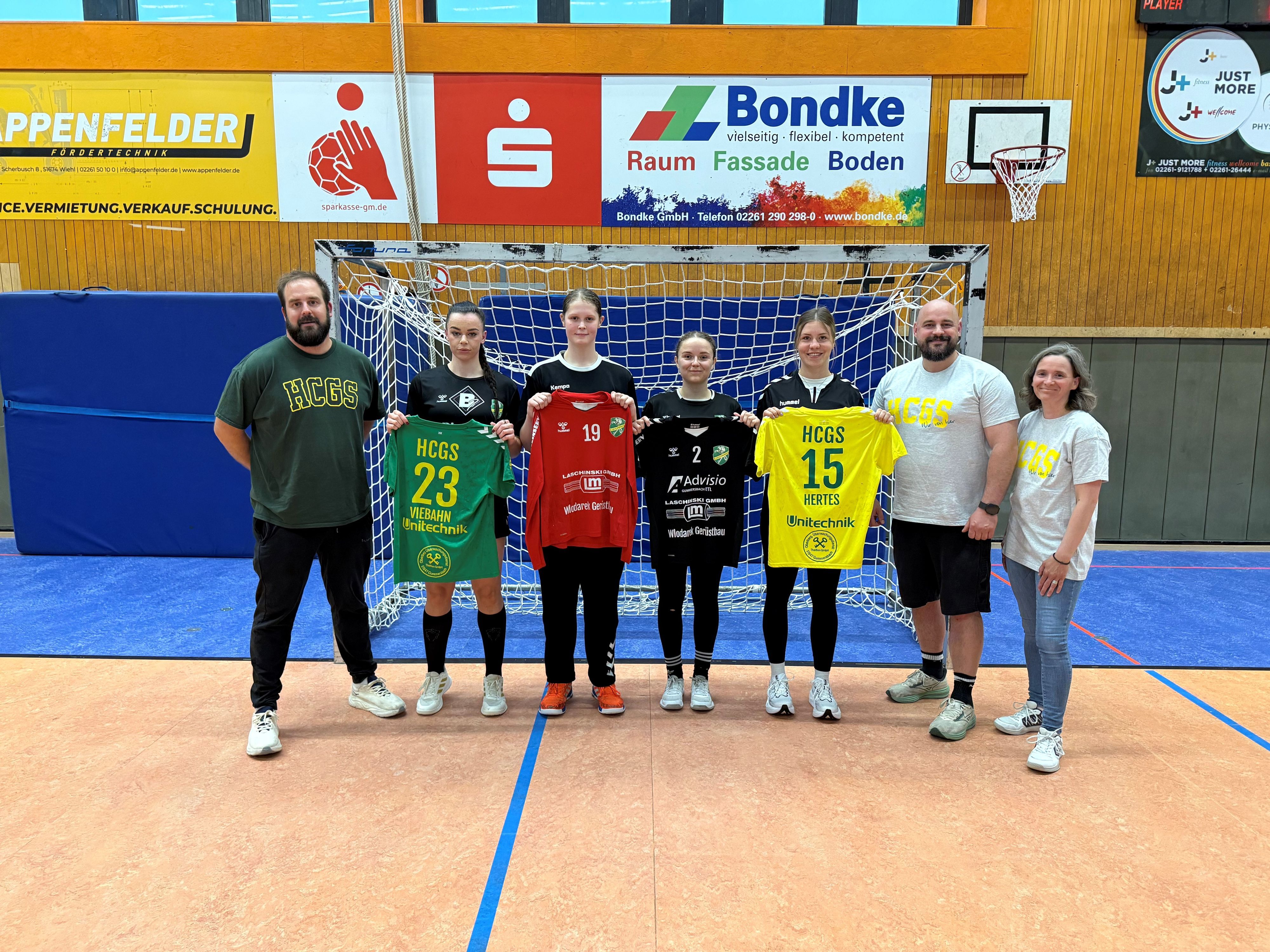 Die neuen Spielerinnen und Verantwortlichen stehen in der Eugen-Haas-Halle vor dem Tor.
