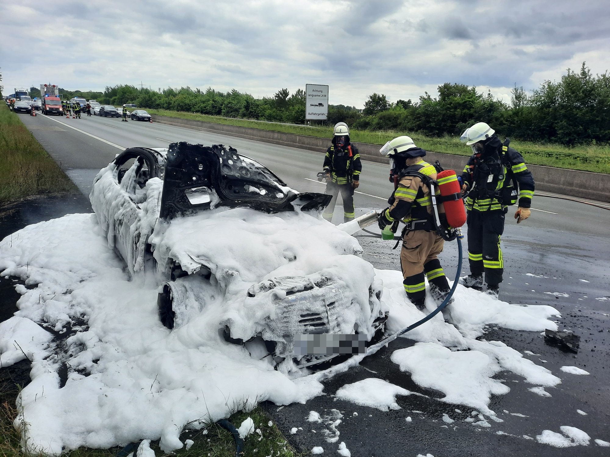 Feuerwehrleute setzen Löschschaum ein.