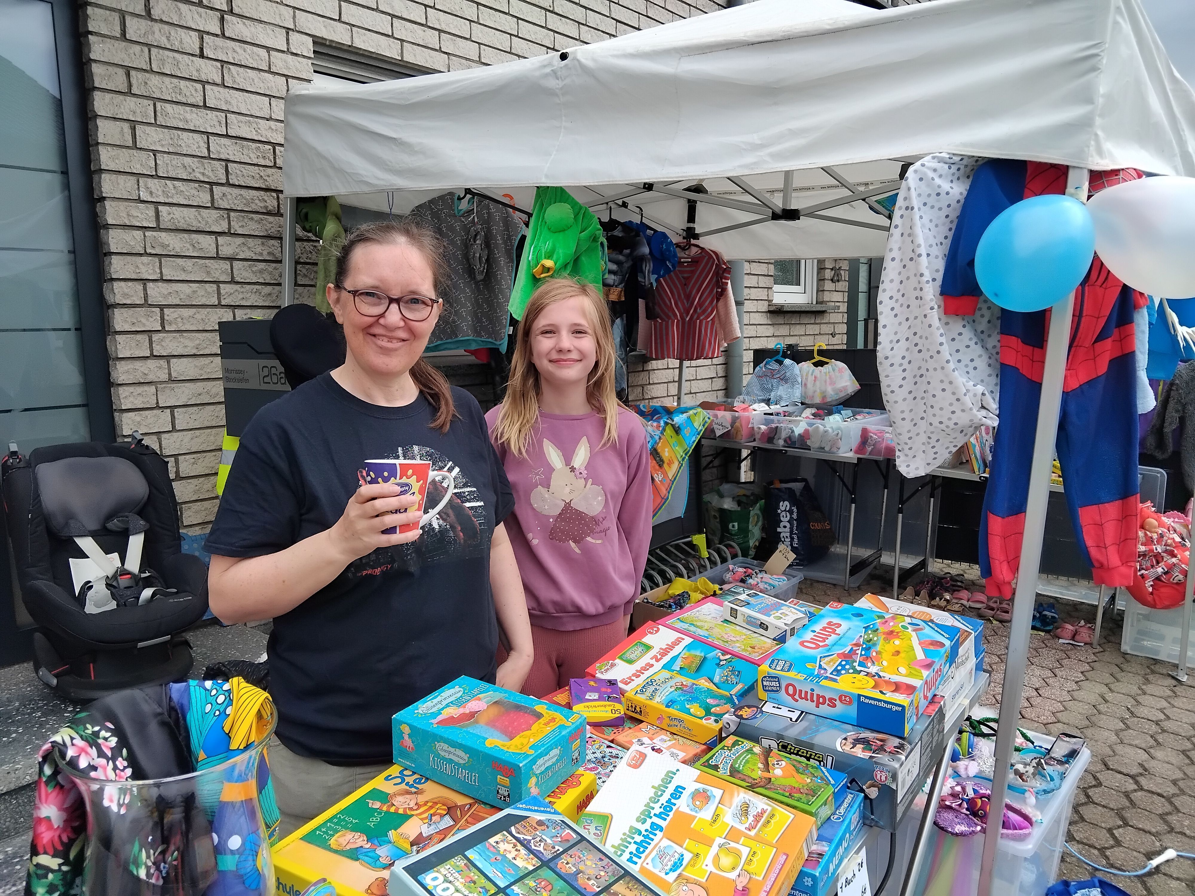Frau mit Kind an einem Flohmarktstand