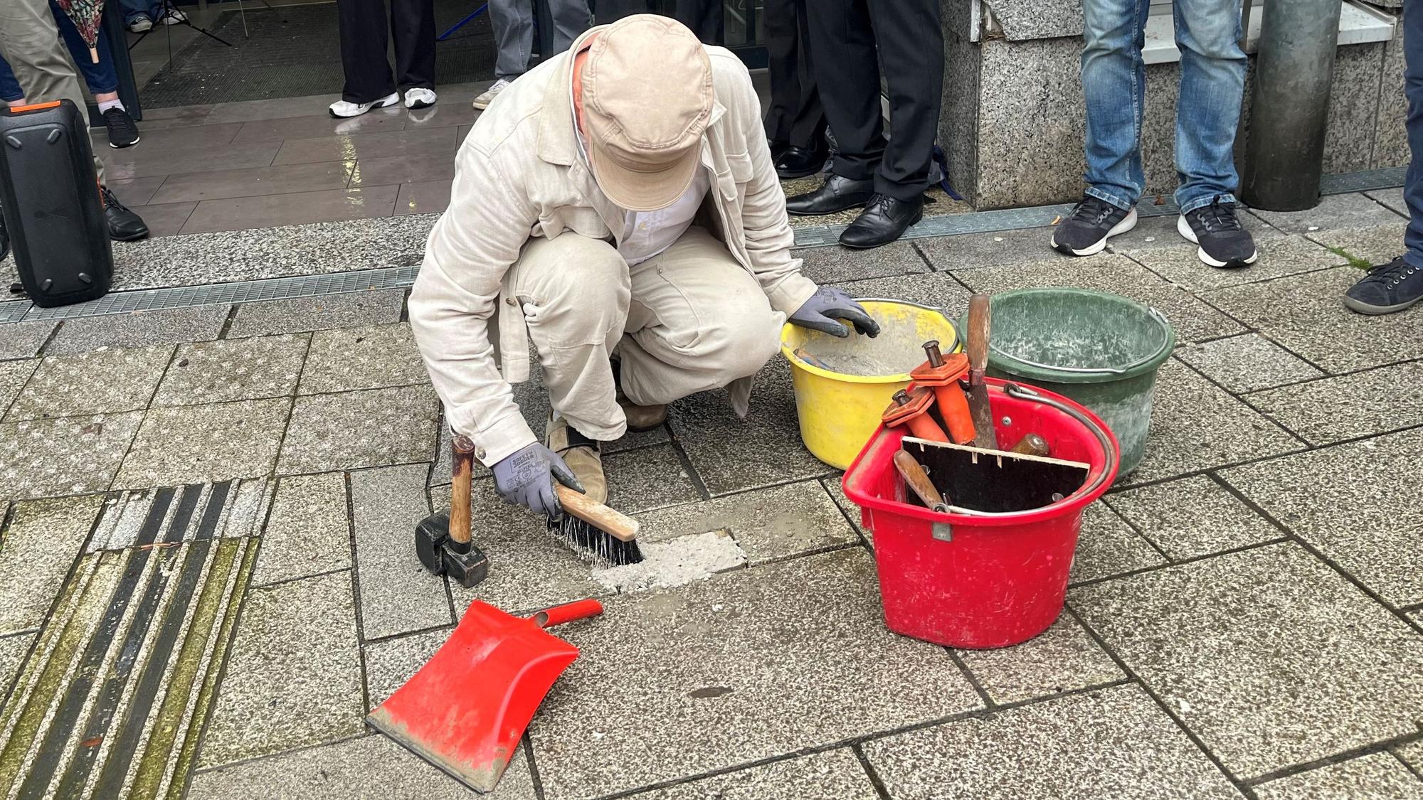 Ein Mann verlegt Stolpersteine