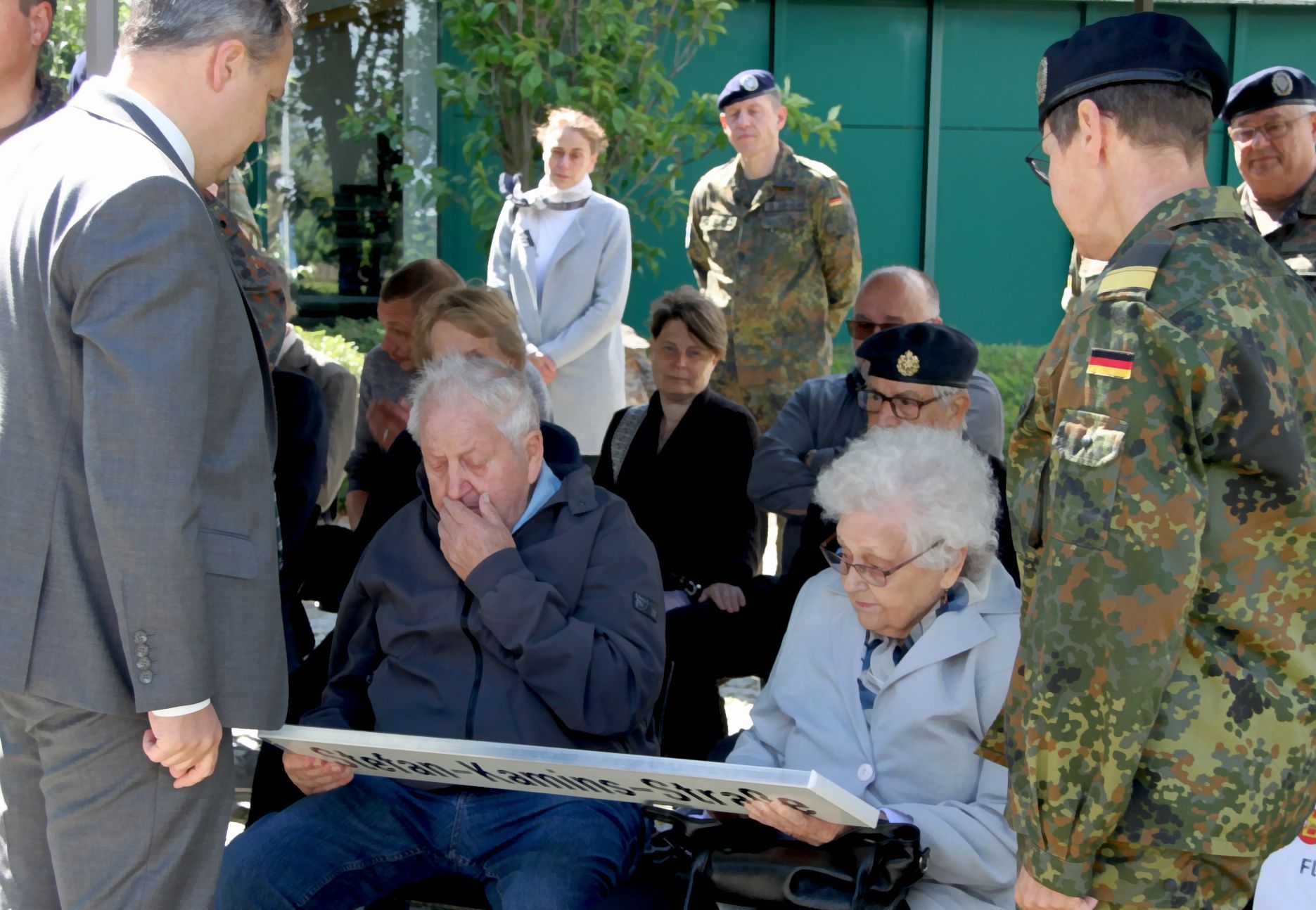 Ein ergreifender Moment: Euskirchens Stadtbürgermeister Sacha Reichelt (links) und Standortälteste Flotillenadmiral Sabine Reppihn überreiche den Eltern von Stefan Kamins eine Kopie des neuen Straßenschildes.