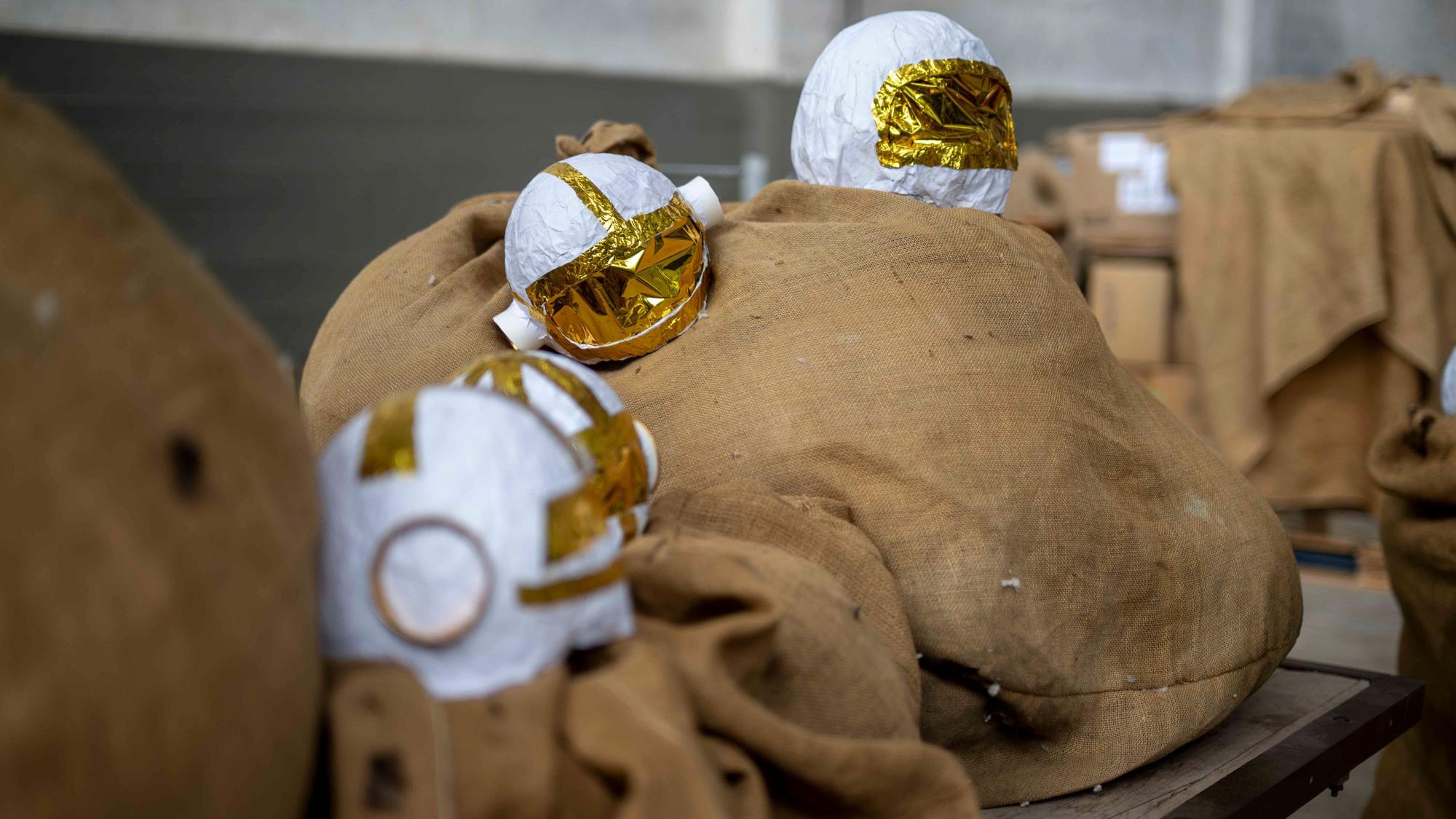 Kleine, gebastelte Astronauten-Helme liegen auf Jutesäcken.