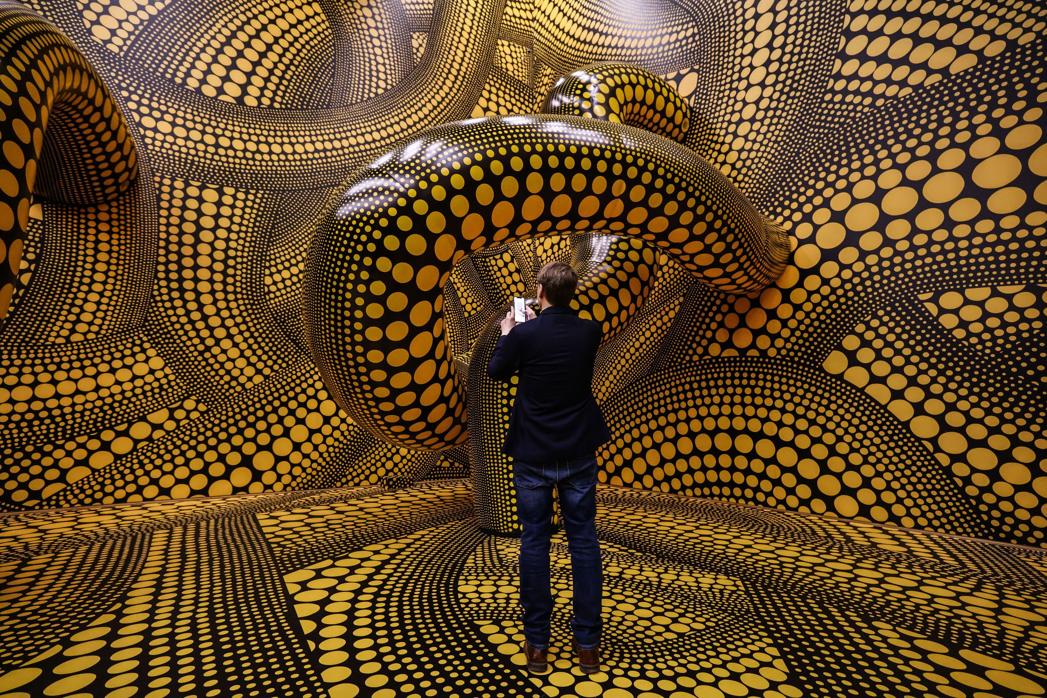 Ein Mann fotografiert die Installation „Hope Polka Dots“ von Yayoi Kusama.