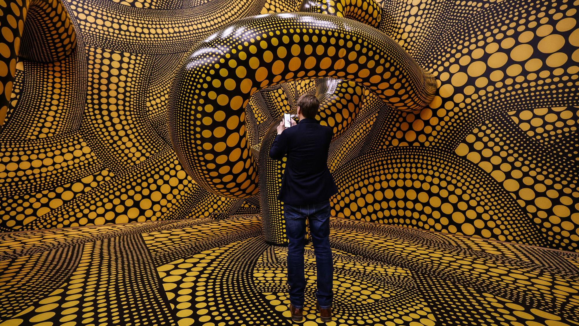 Ein Mann fotografiert die Installation „Hope Polka Dots“ von Yayoi Kusama.