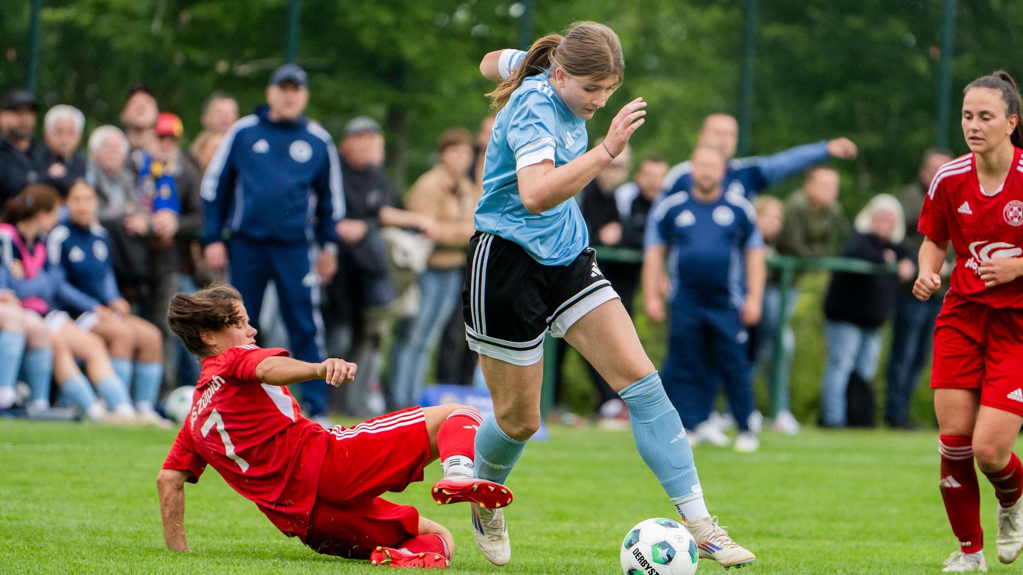 Milena Ronig grätscht in Ina Schneiders und trifft sie am Schienbein.