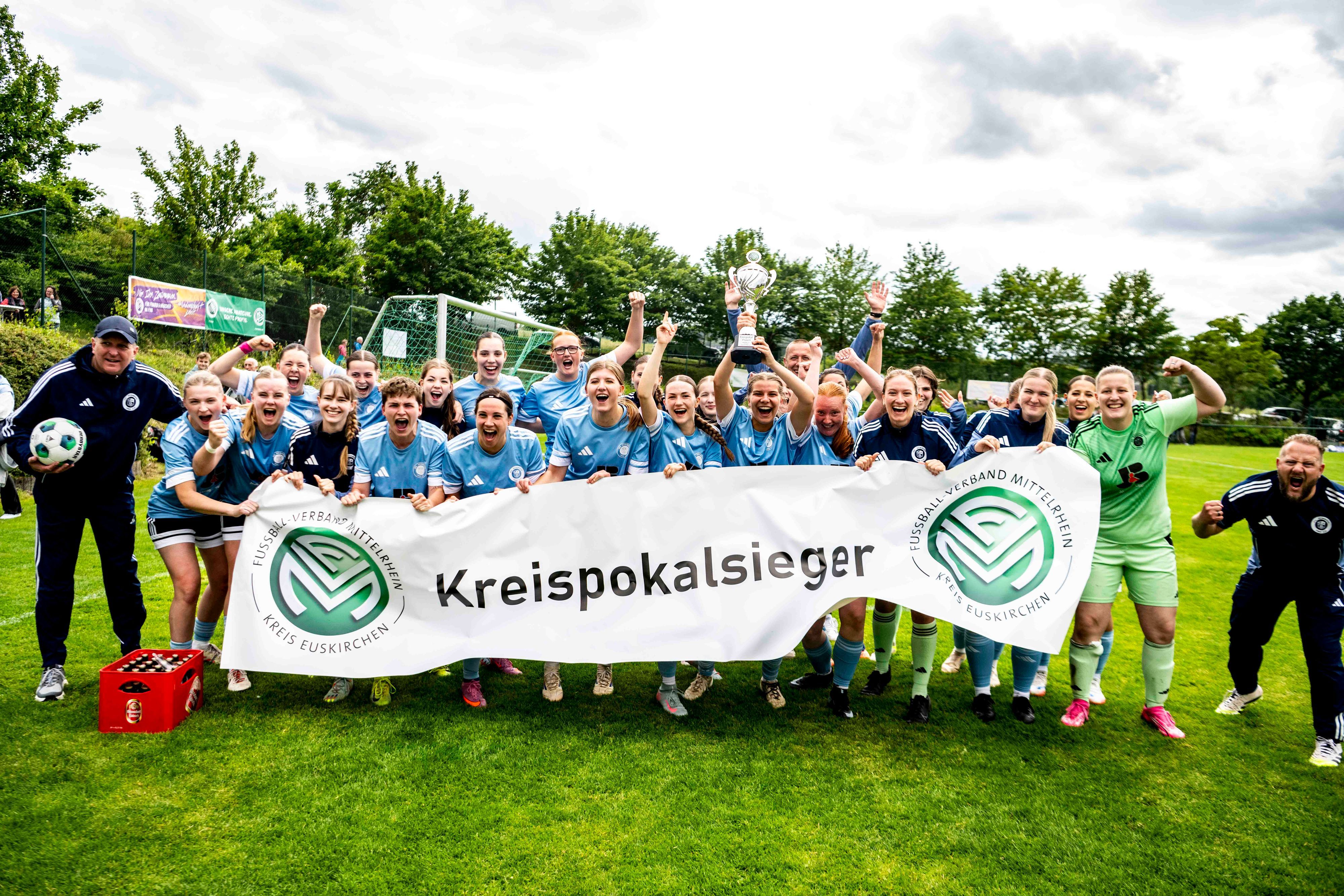 Die Mannschaft des VfL Kommern jubelt und hält das Kreispokalbanner des Fußballkreises in die Höhe.