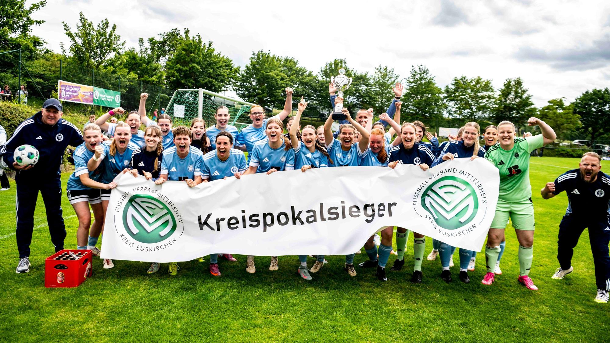 Die Mannschaft des VfL Kommern jubelt und hält das Kreispokalbanner des Fußballkreises in die Höhe.