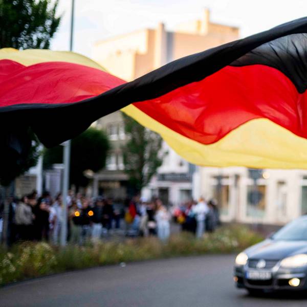 Eine Frau läuft mit einer riesiegen Deutschland-Fahne durch den Kreisel.