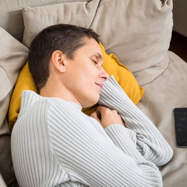 Eine Frau schläft auf einem Sofa
