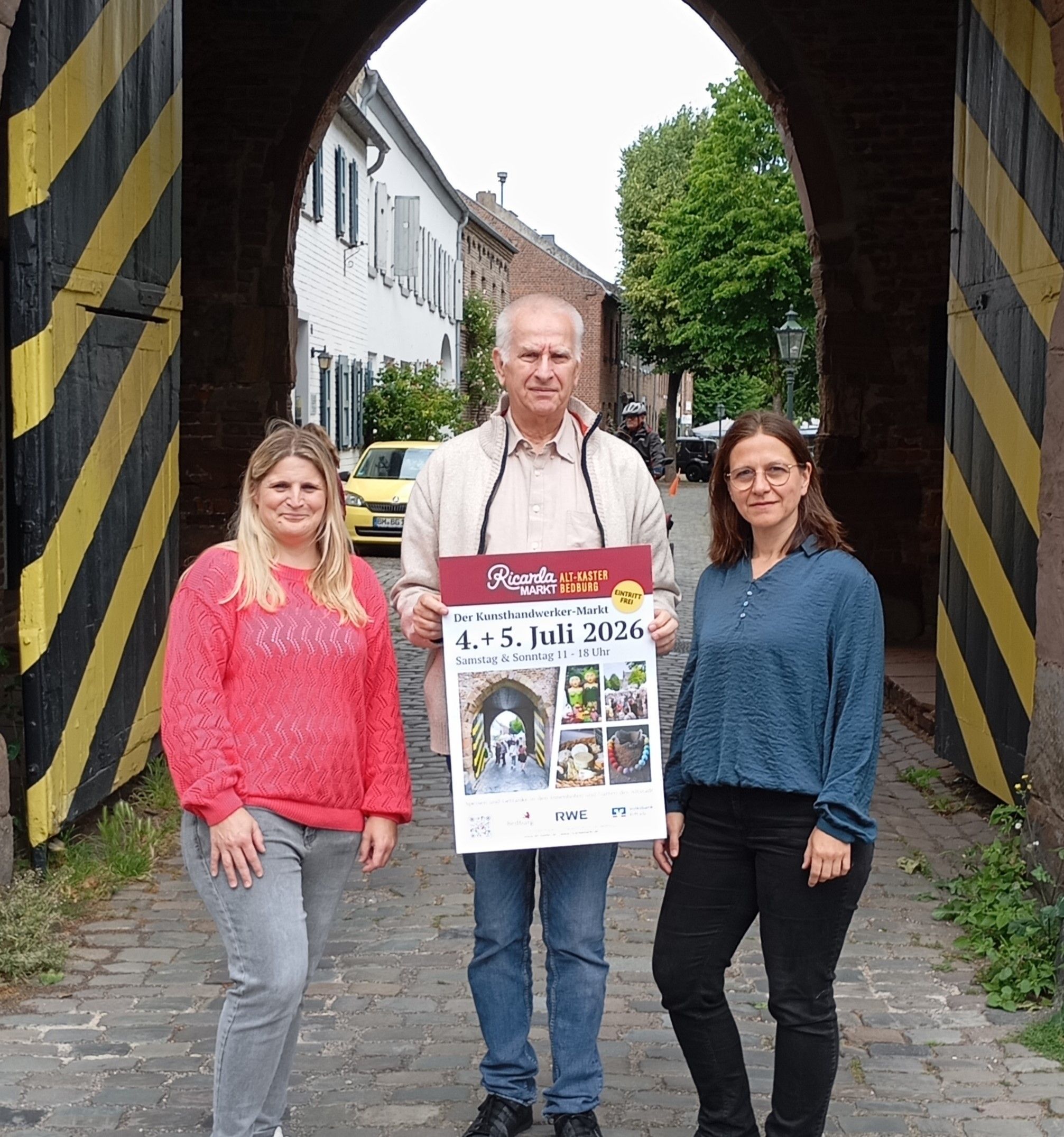 Zu sehen sind zwei Frauen und ein Mann vor dem Agathator in Alt-Kaster.