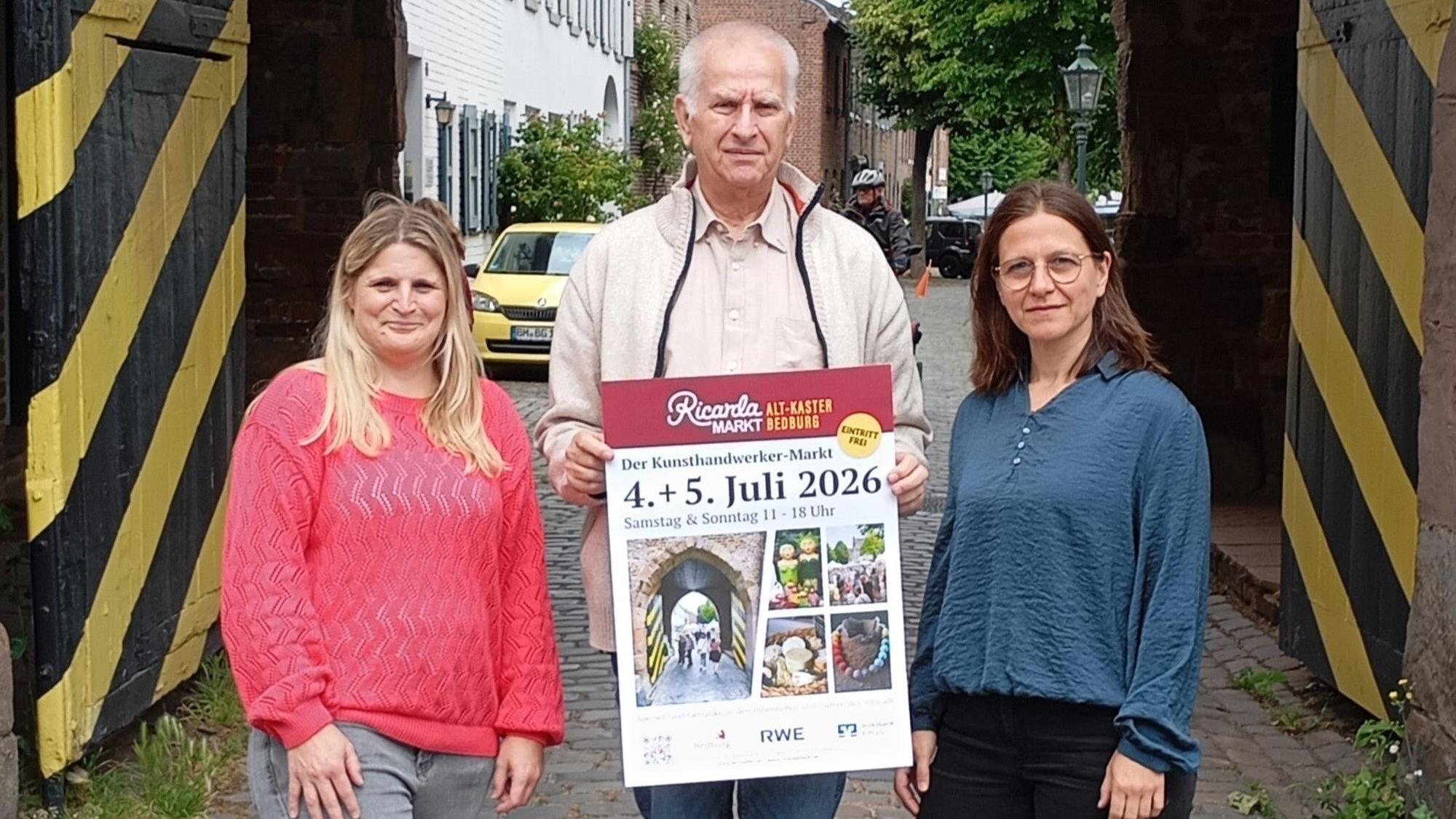 Zu sehen sind zwei Frauen und ein Mann vor dem Agathator in Alt-Kaster.