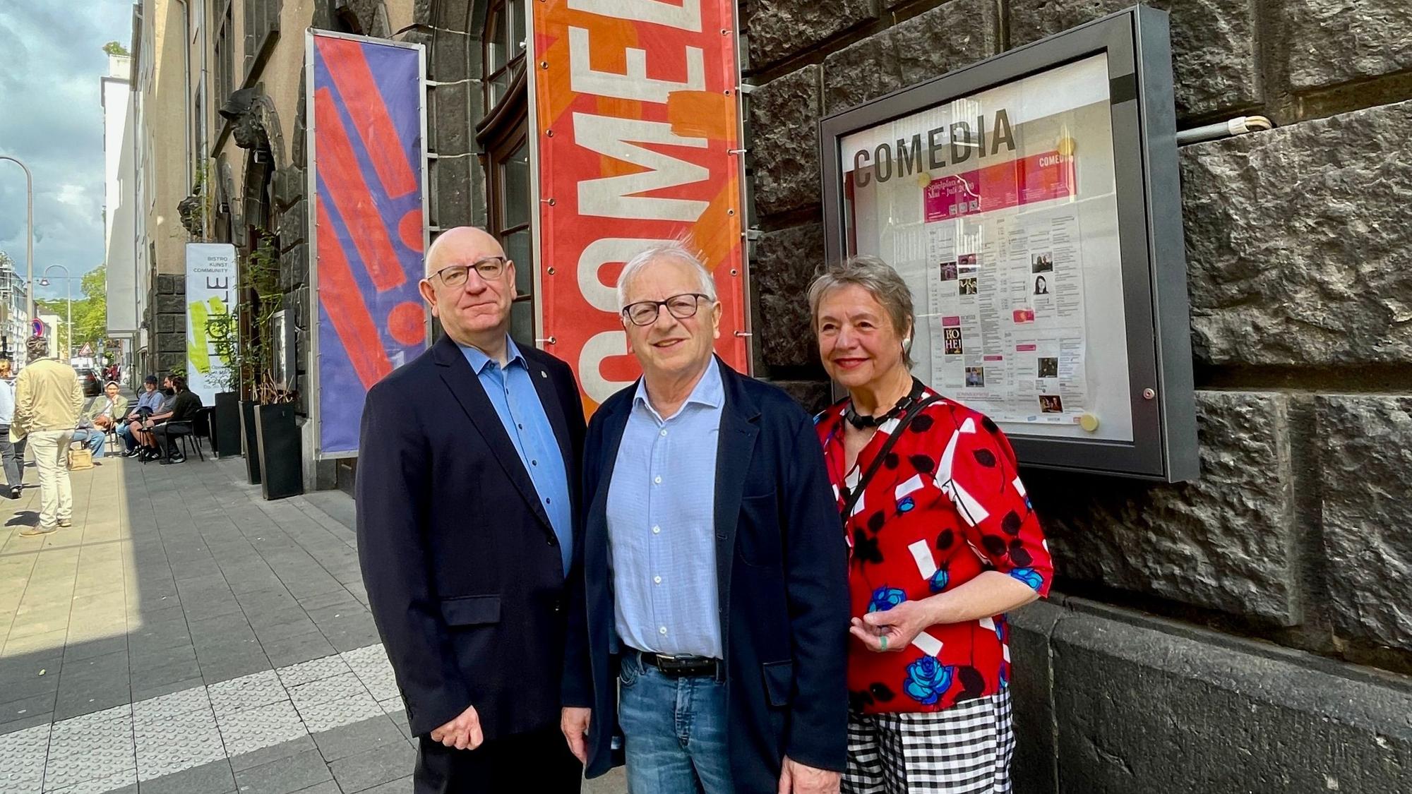 Zwei Männer und eine Frau stehen vor dem Gebäude der Comedia.