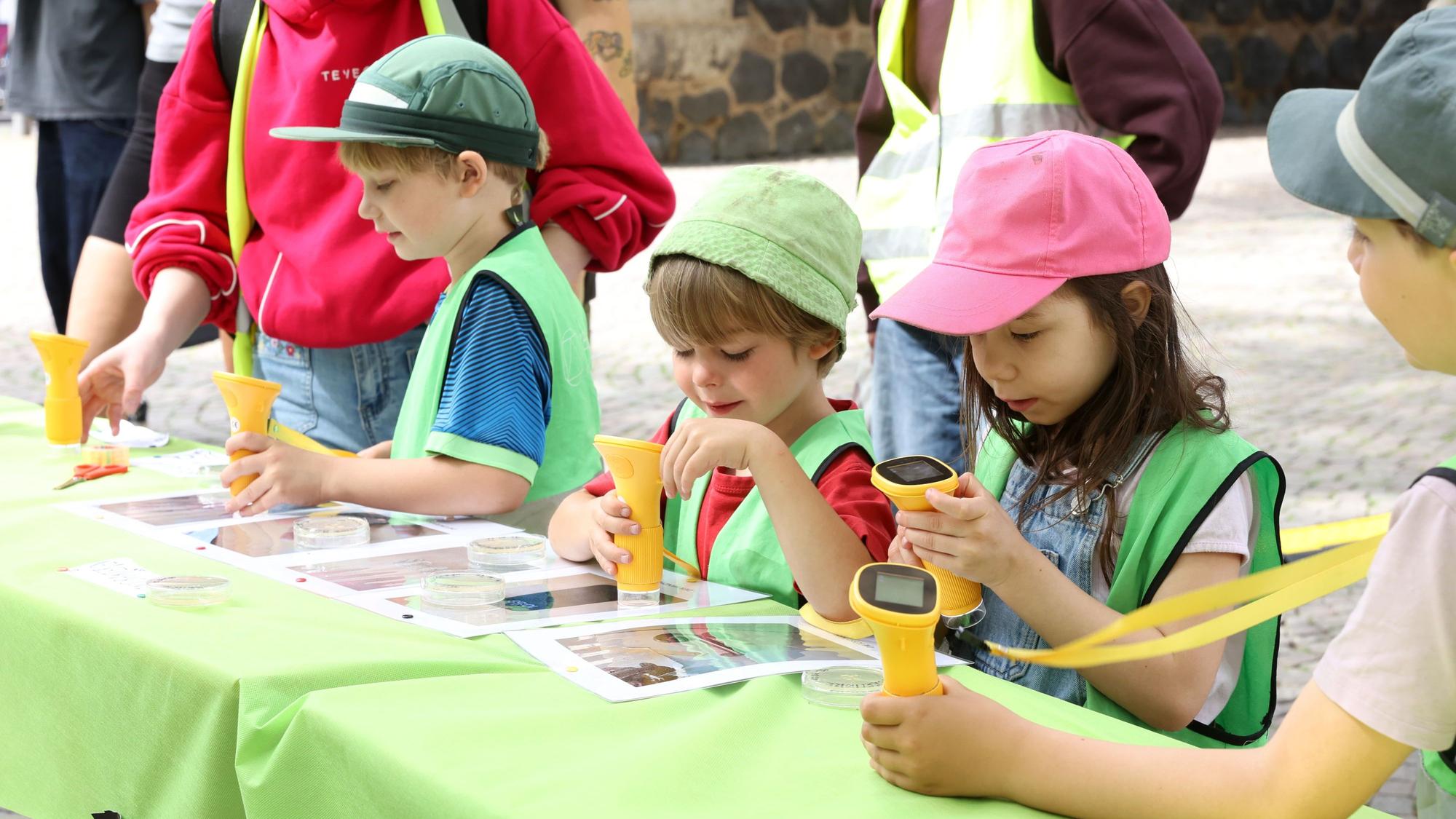 Kita-Kinder stehen an einem Tisch auf dem Rudolfplatz